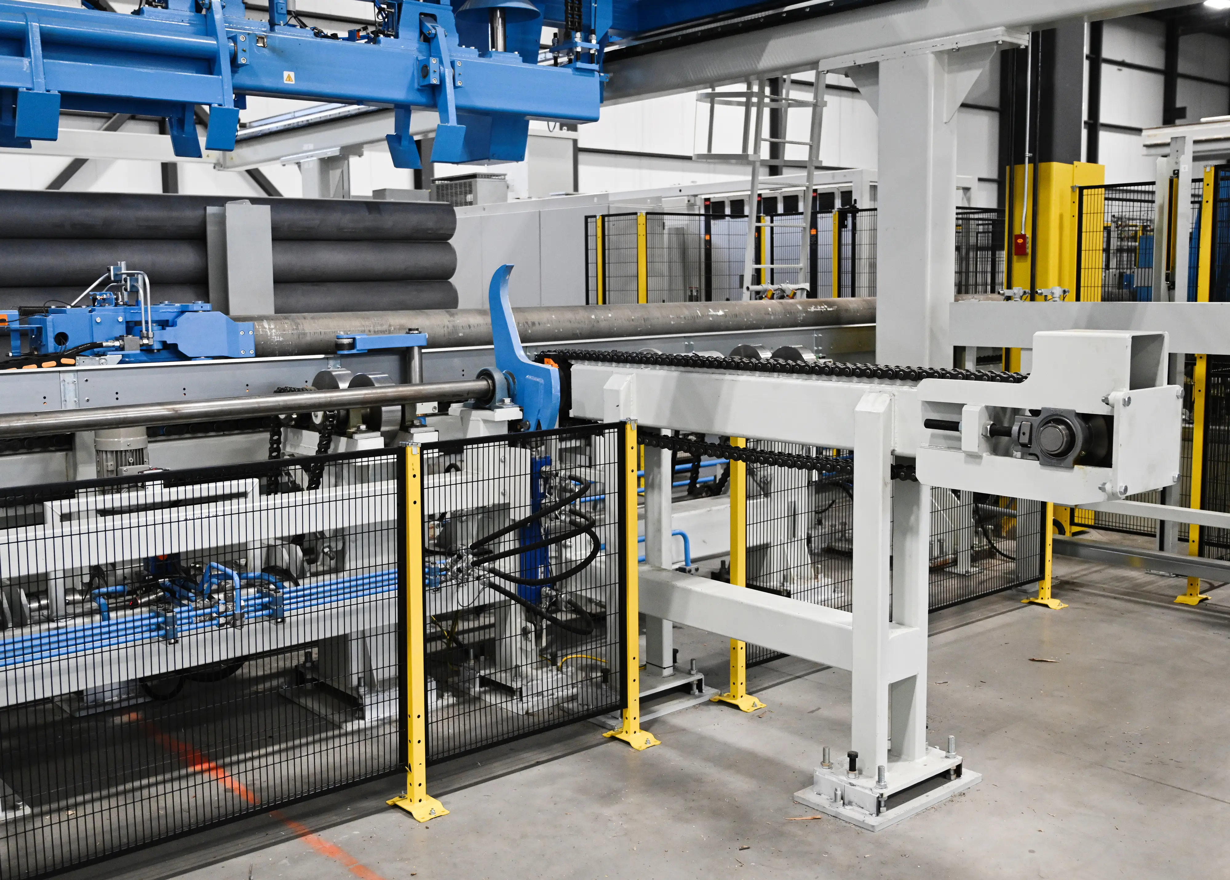 Grey, light blue, and yellow machinery sit inside a Canadian aluminum-making Magna factory.
