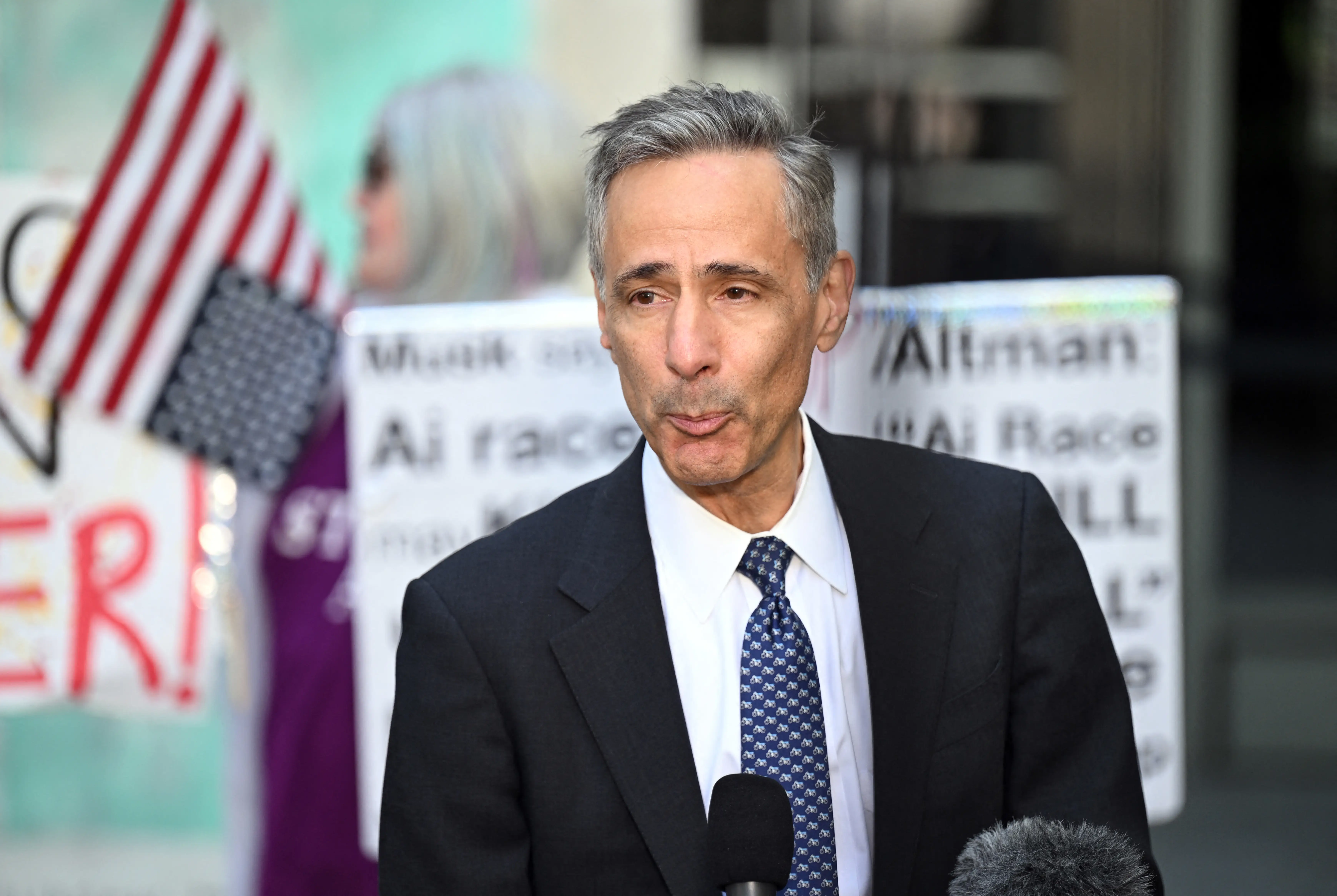 William Savitt stands at the microphones
