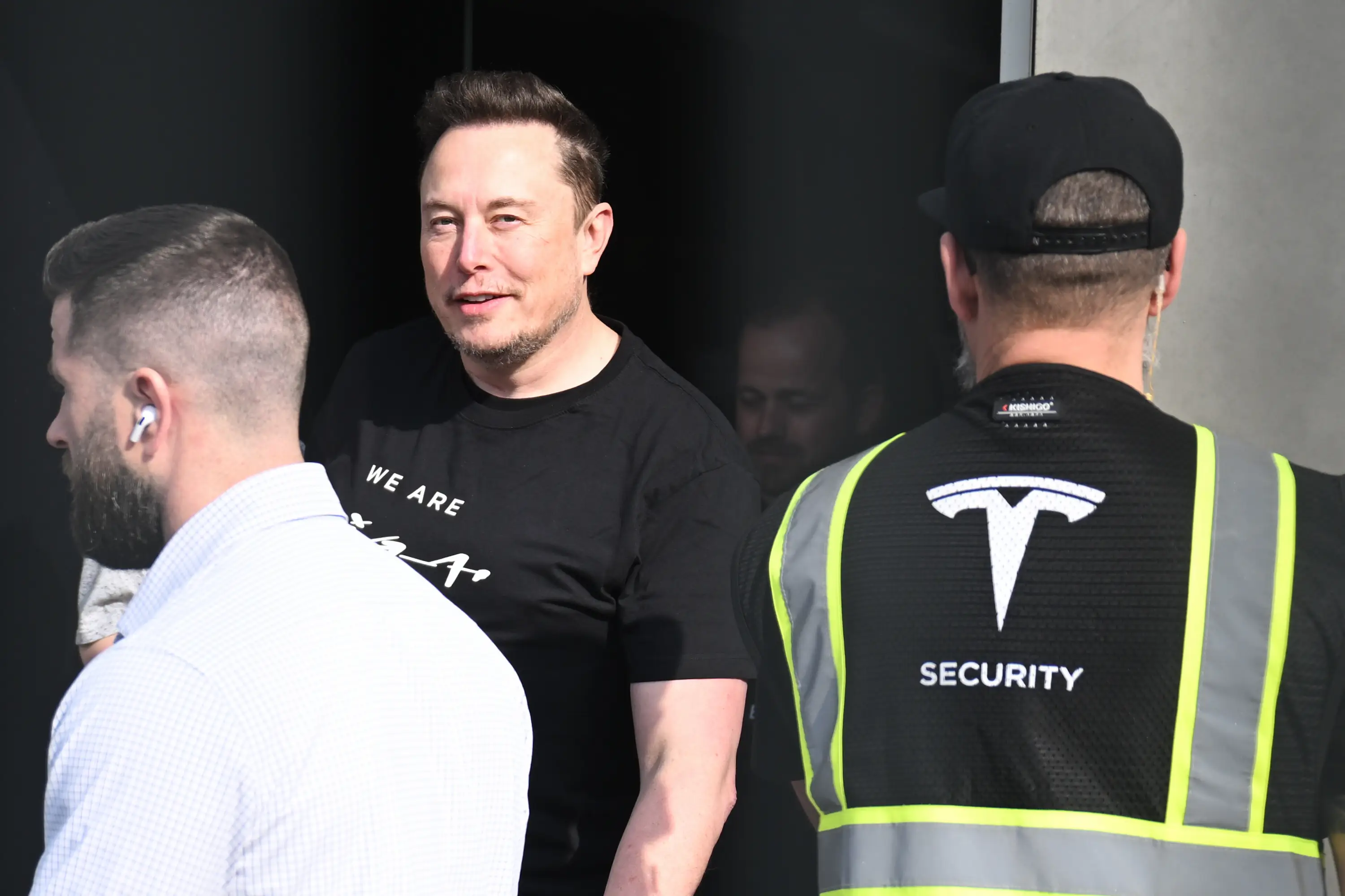 Tesla CEO Elon Musk leaves the Tesla Gigafactory Berlin-Brandenburg with security personnel around him.