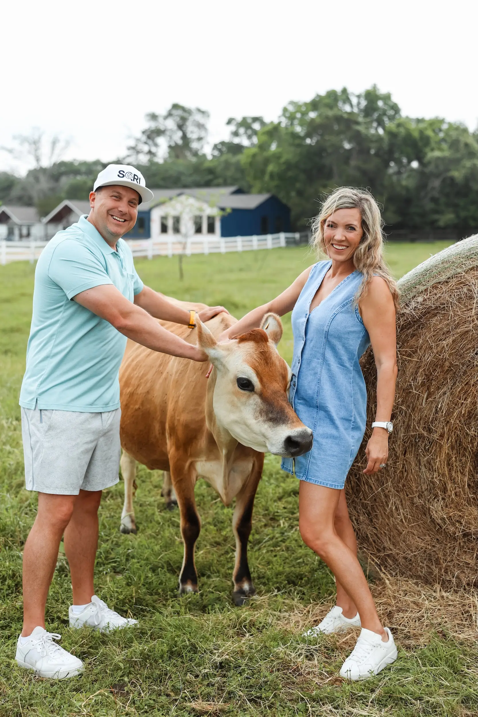 A man and woman posing with a cow.