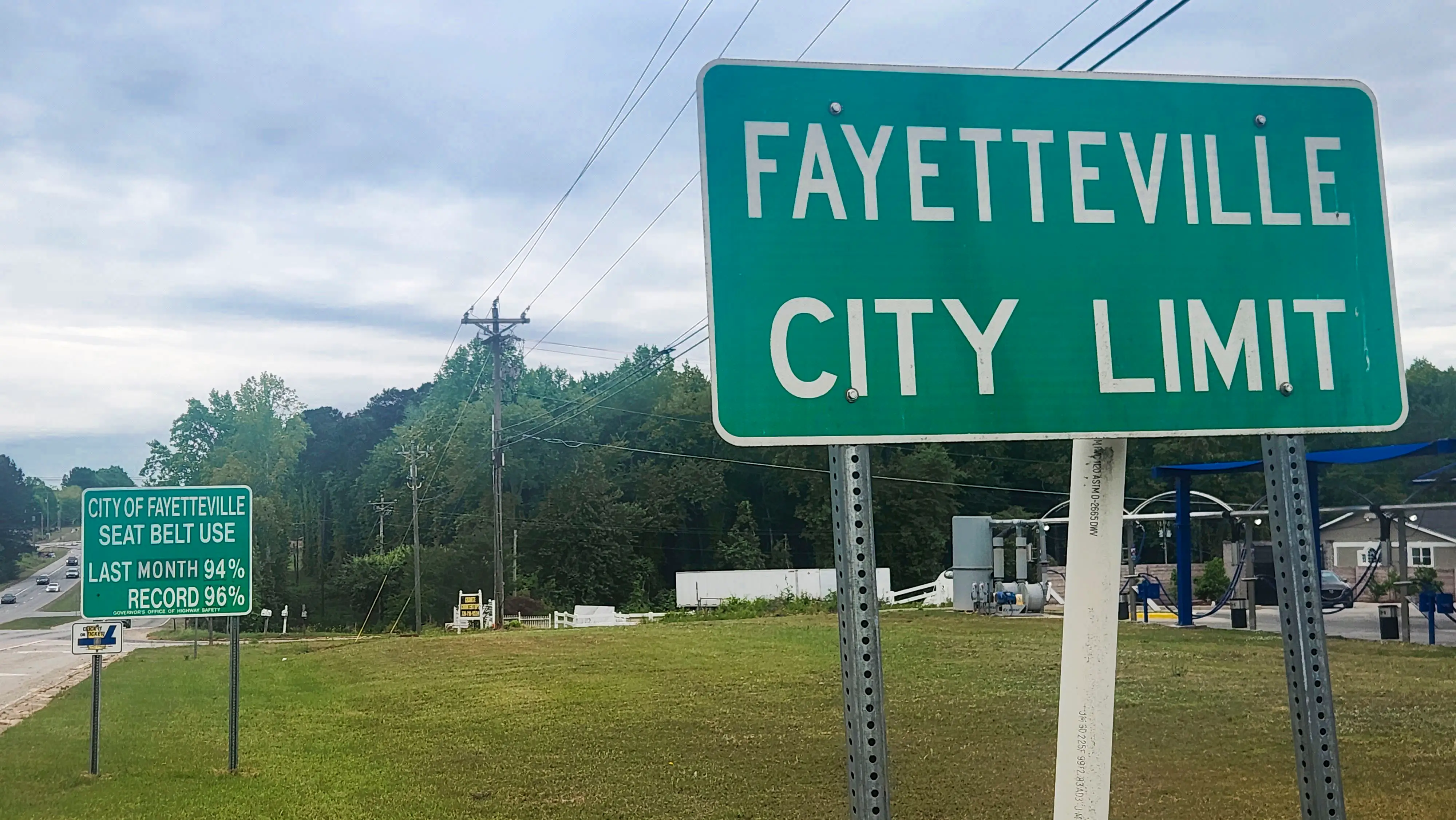 A sign for Fayetteville City Limit with the proposed data center site in the background.