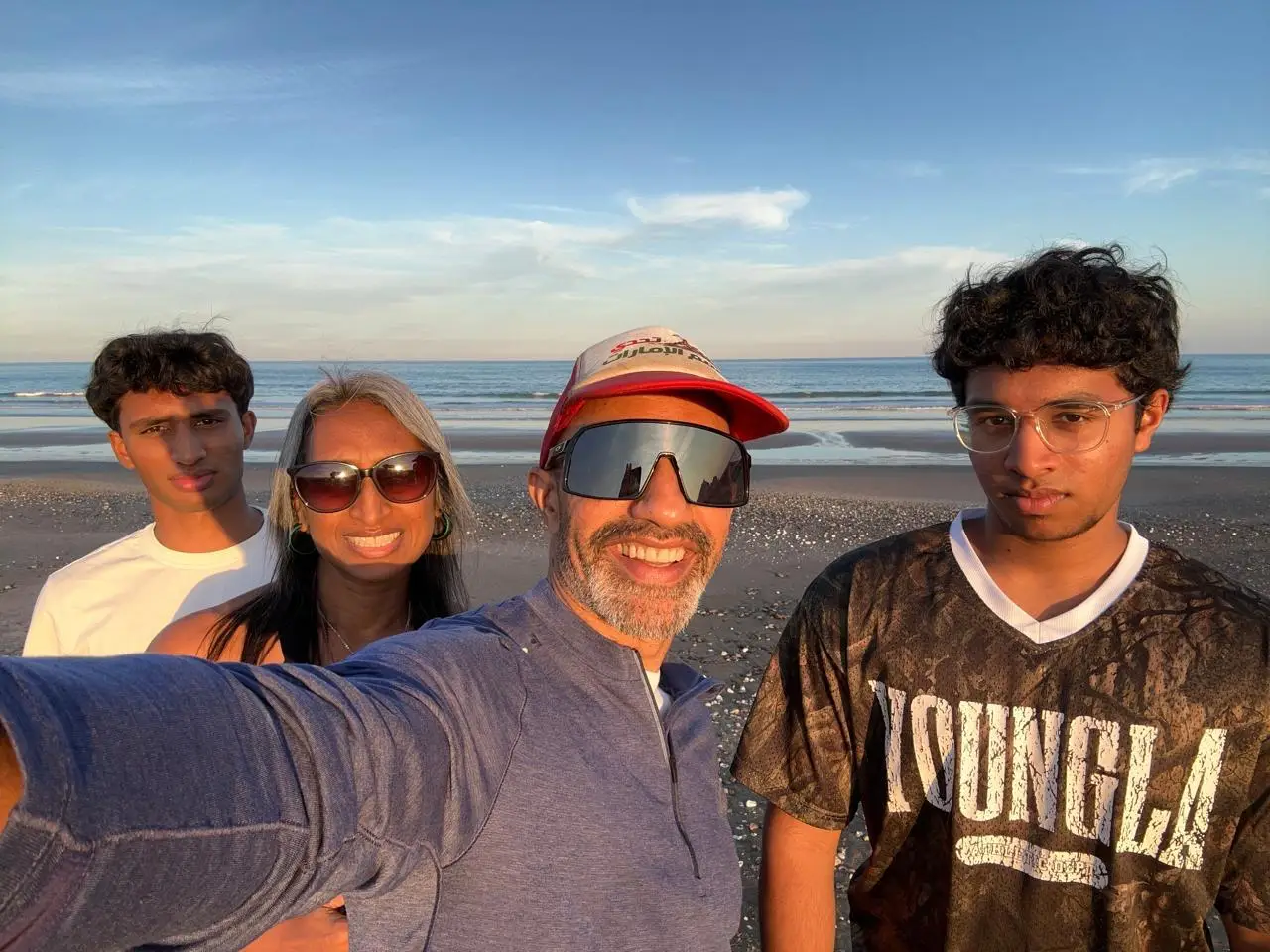 A family taking a selfie on a beach.