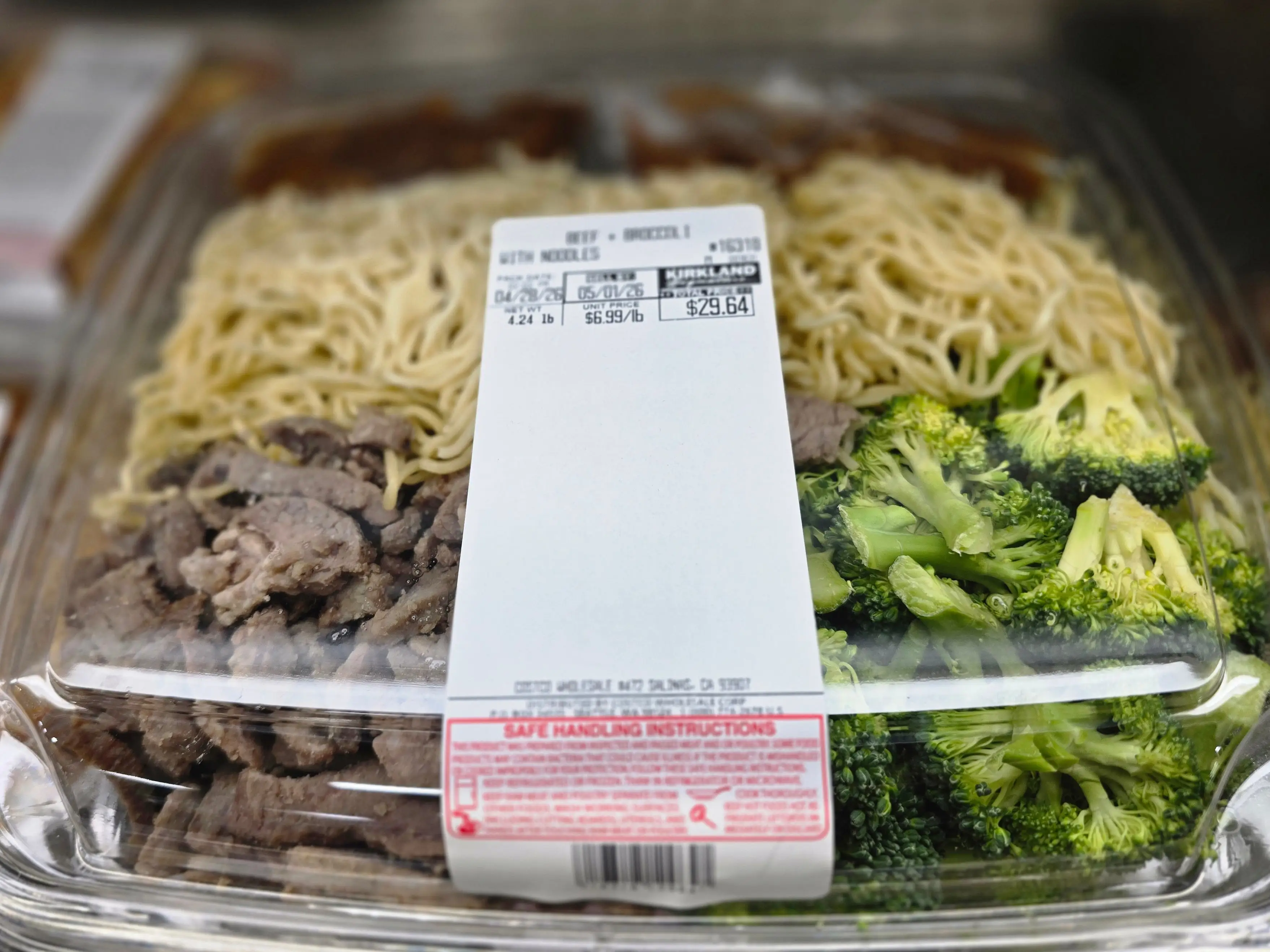 A container of premade Kirkland Signature beef and broccoli.
