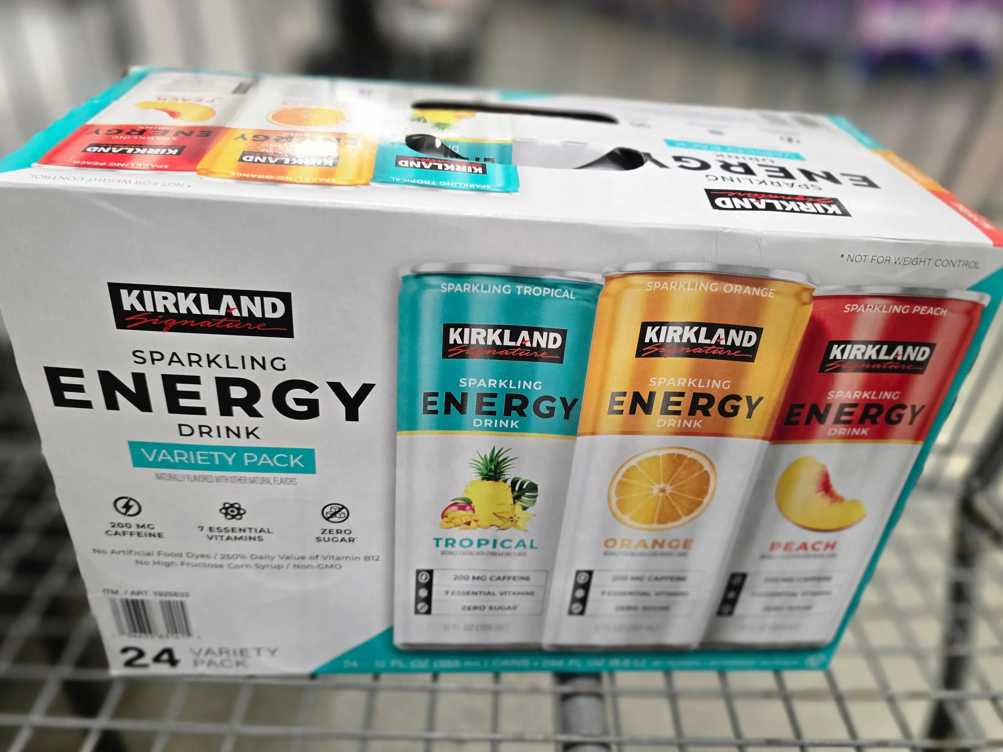 A box of Kirkland Signature sparkling energy drinks in a shopping cart.