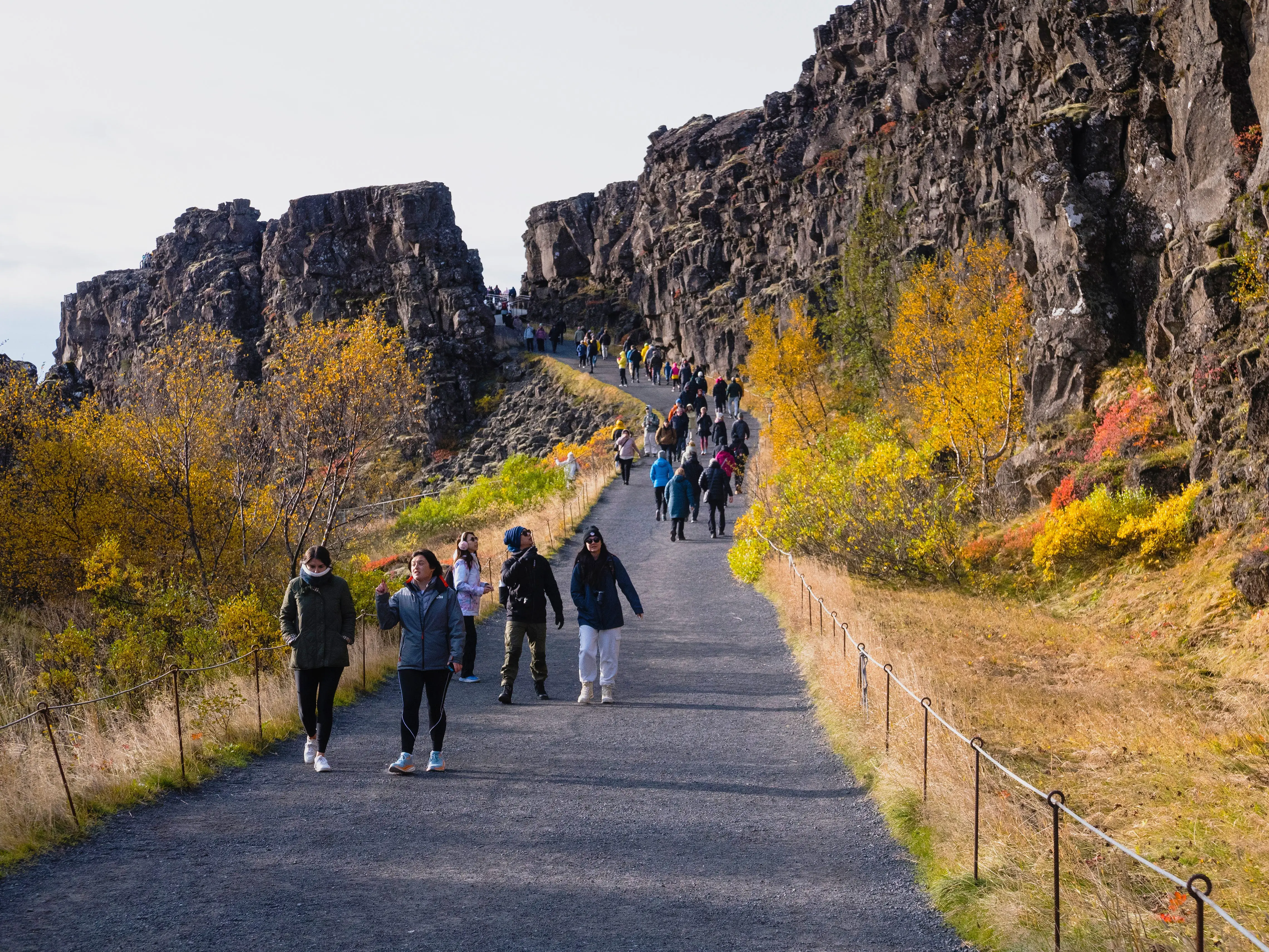 Visitors walk along the trail of Thingvellir National Park in Iceland.