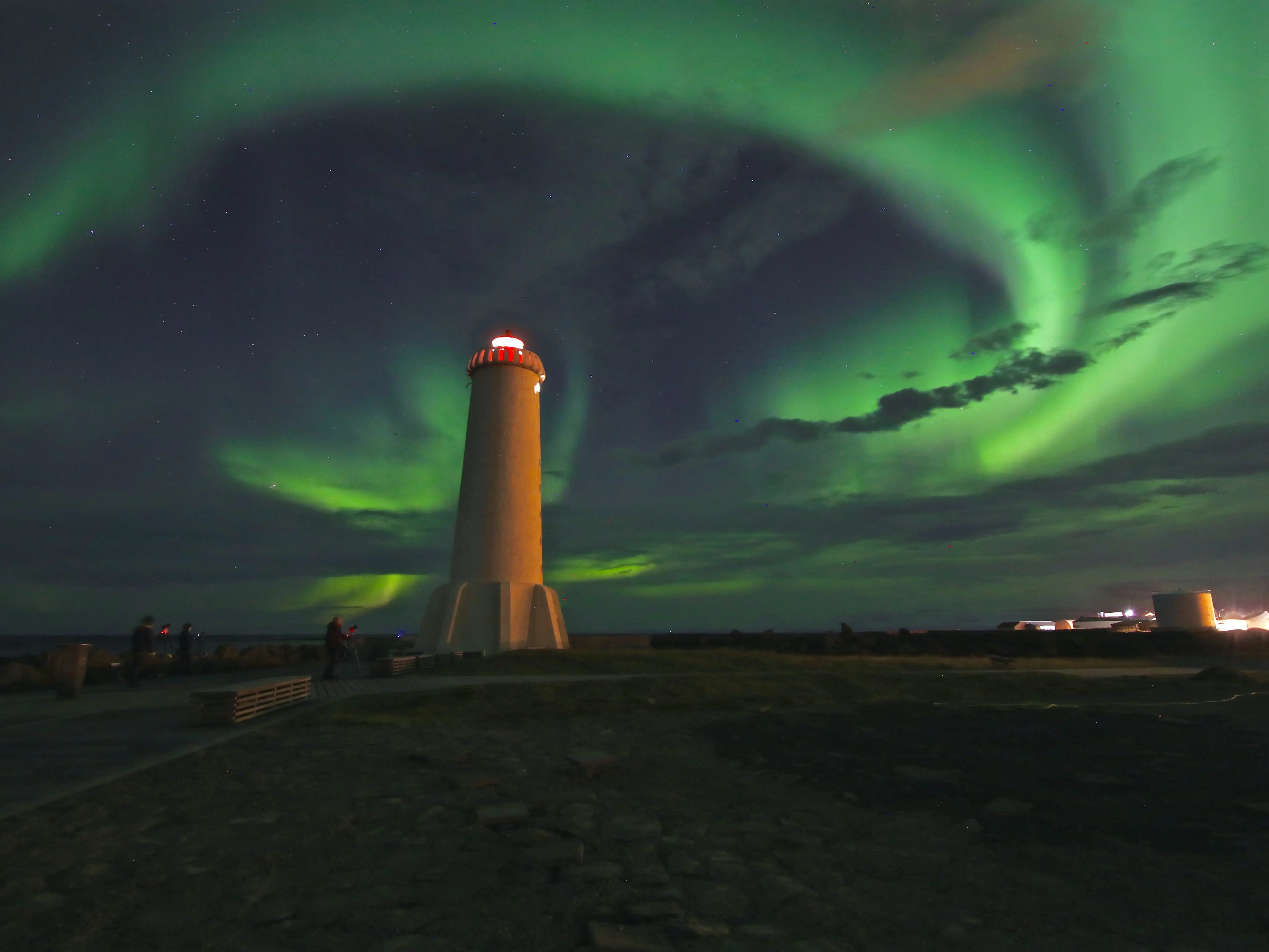 The northern lights dance around a lighthouse in Akranes, Iceland.