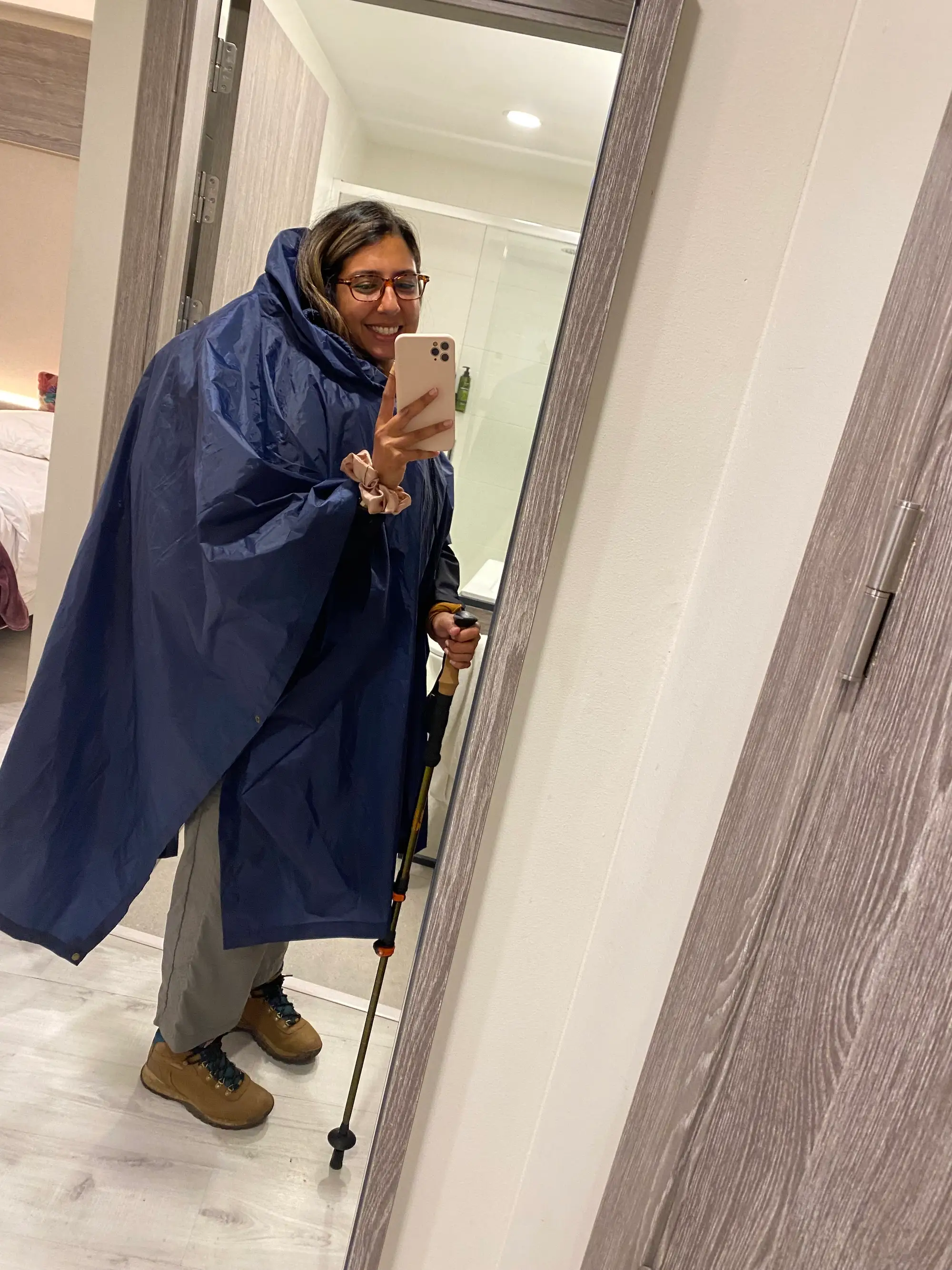 Shirin Ahmadi wearing a poncho while standing in front of a mirror to take a selfie.
