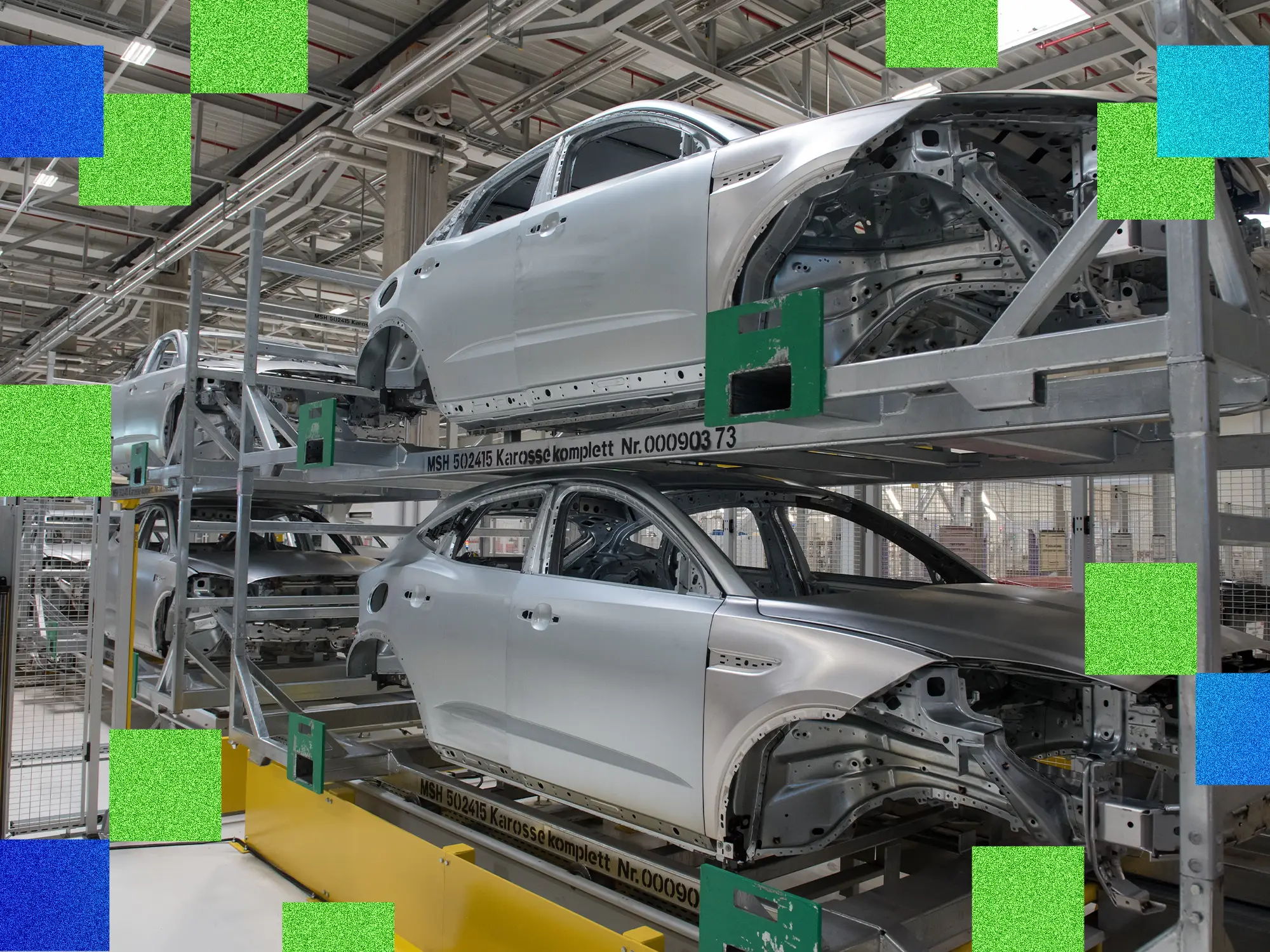 Several Jaguar E-Pace exoskeletons sit on a Magna factory line ahead of their subchassis and motor manufacturing.