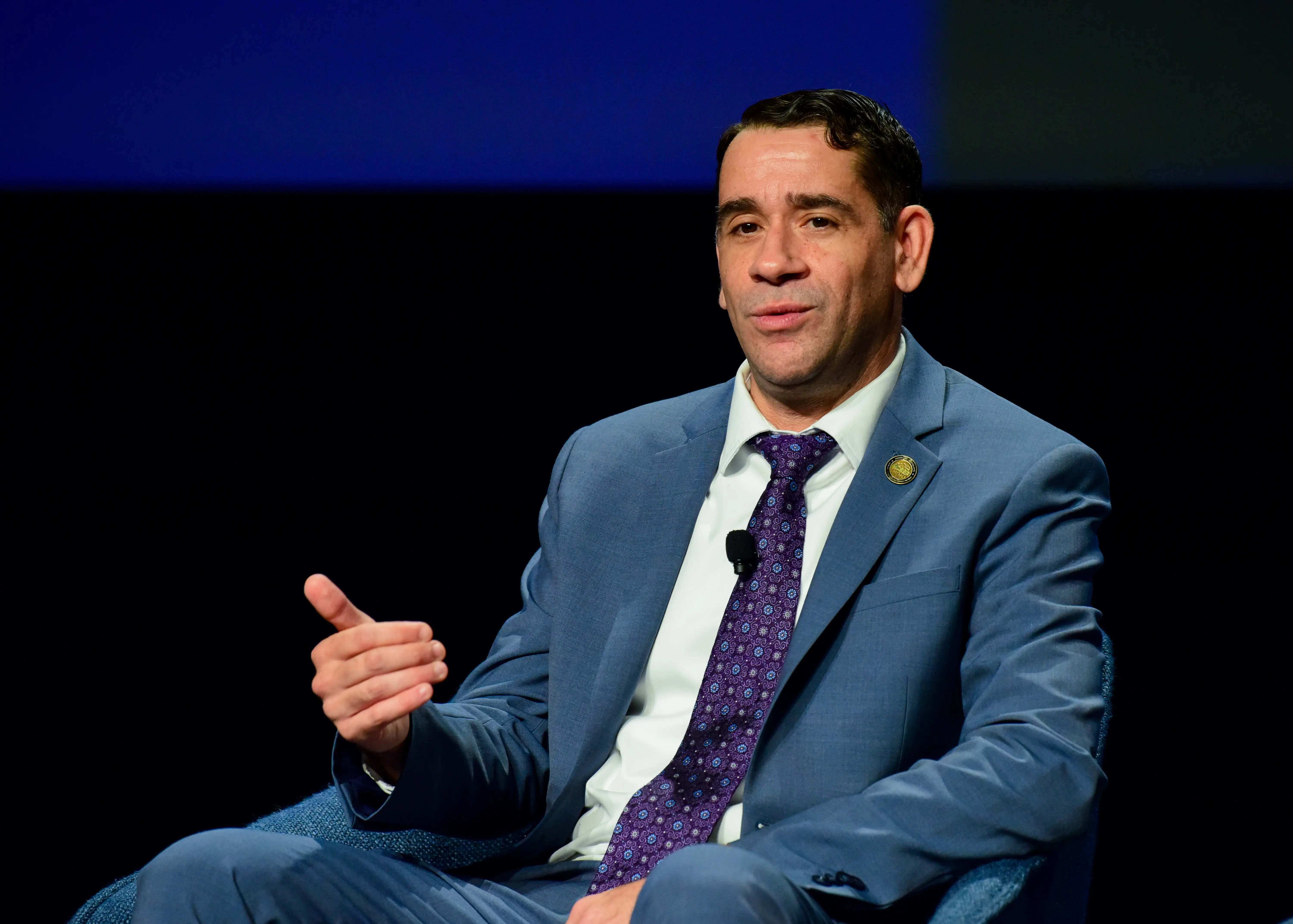 Leonel Garciga, the US Army's former chief information officer, sits in a blue suit.