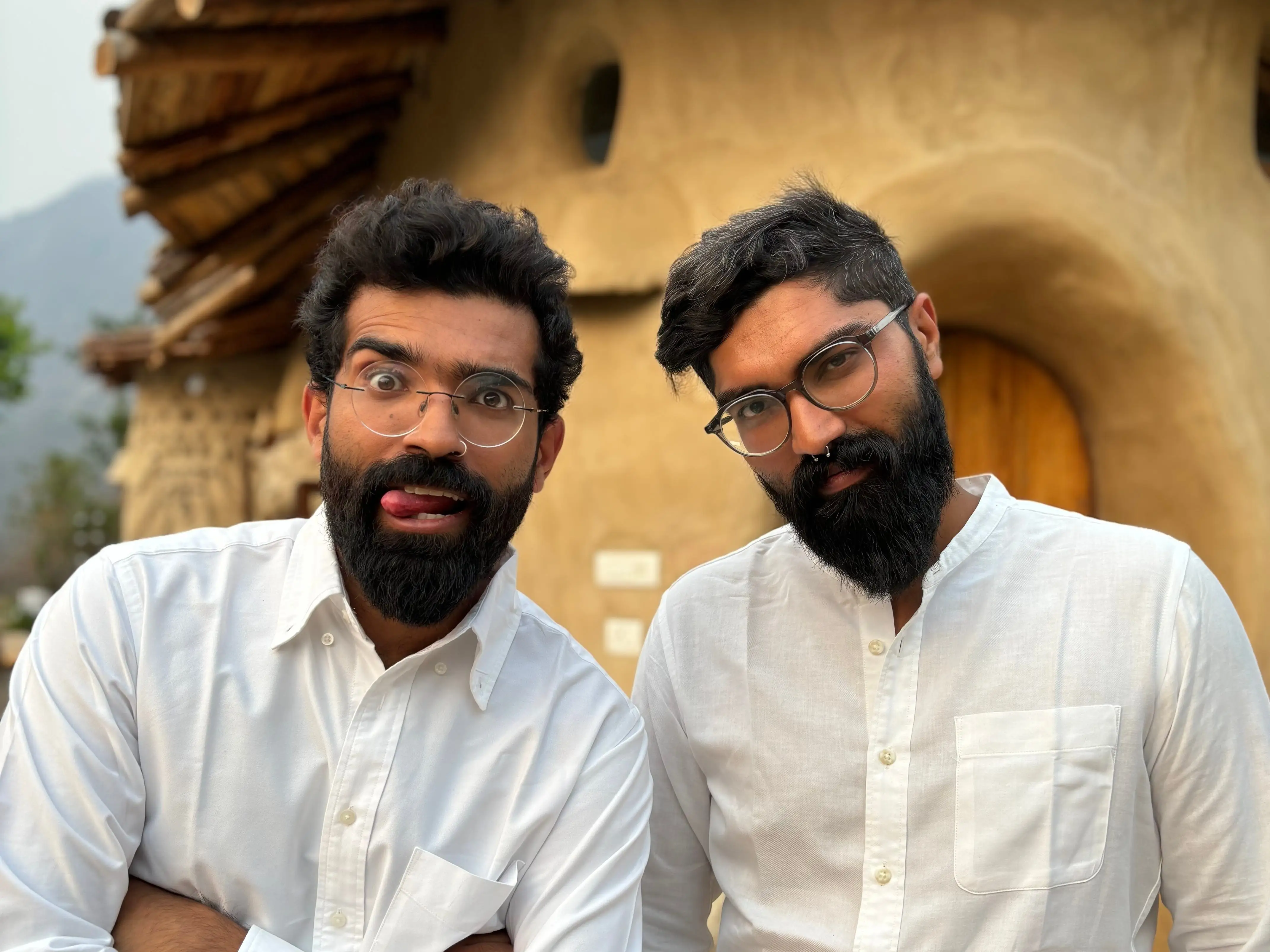 Ansh and Raghav Kumar in front of the mud villa they built in Rishikesh.