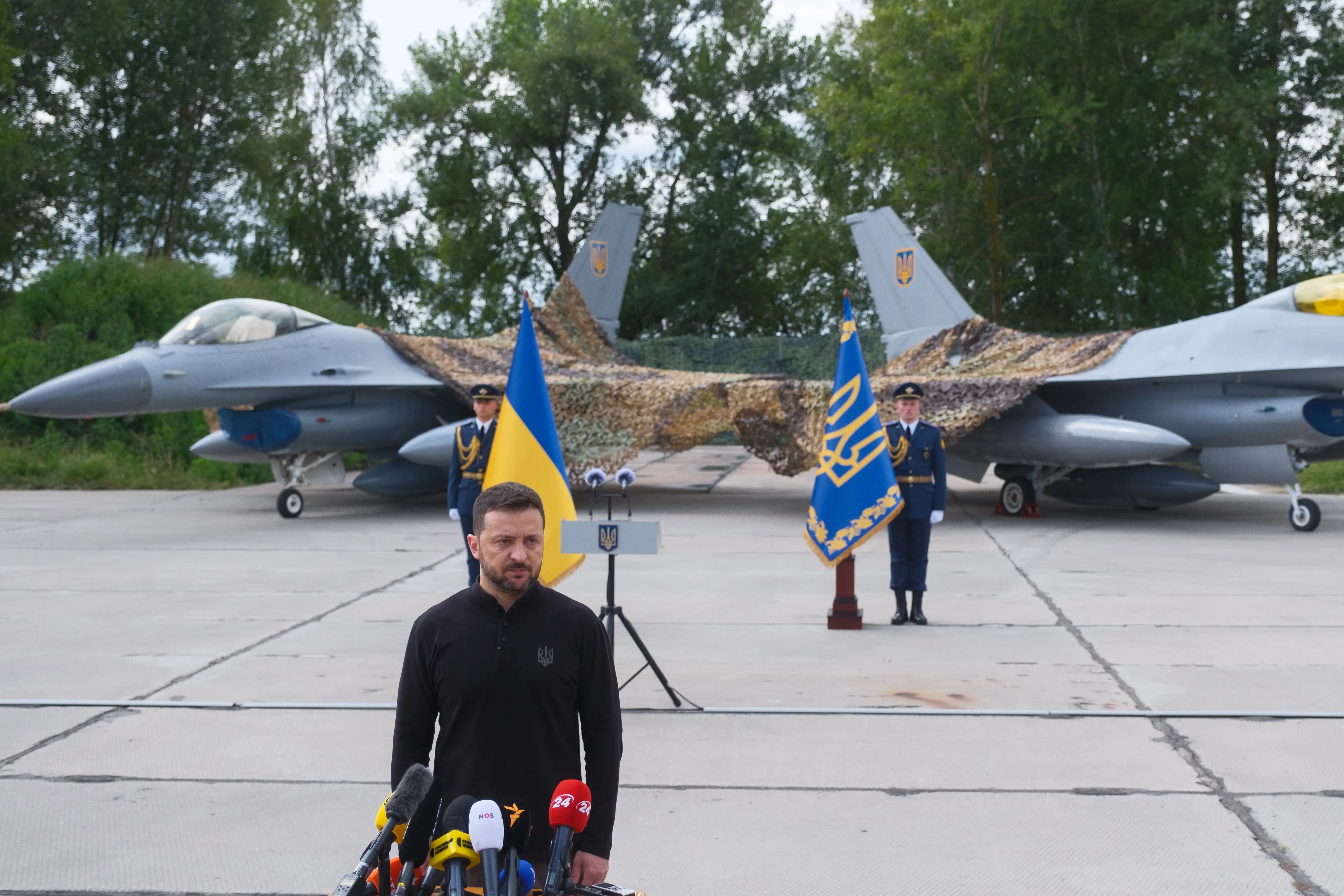 President of Ukraine Volodymyr Zelenskyy stands in front of the first General Dynamics F-16 Fighting Falcons received by Ukraine as he congratulates the Ukrainian military on the Day of the Ukrainian Air Force on August 4, 2024, in Ukraine.
