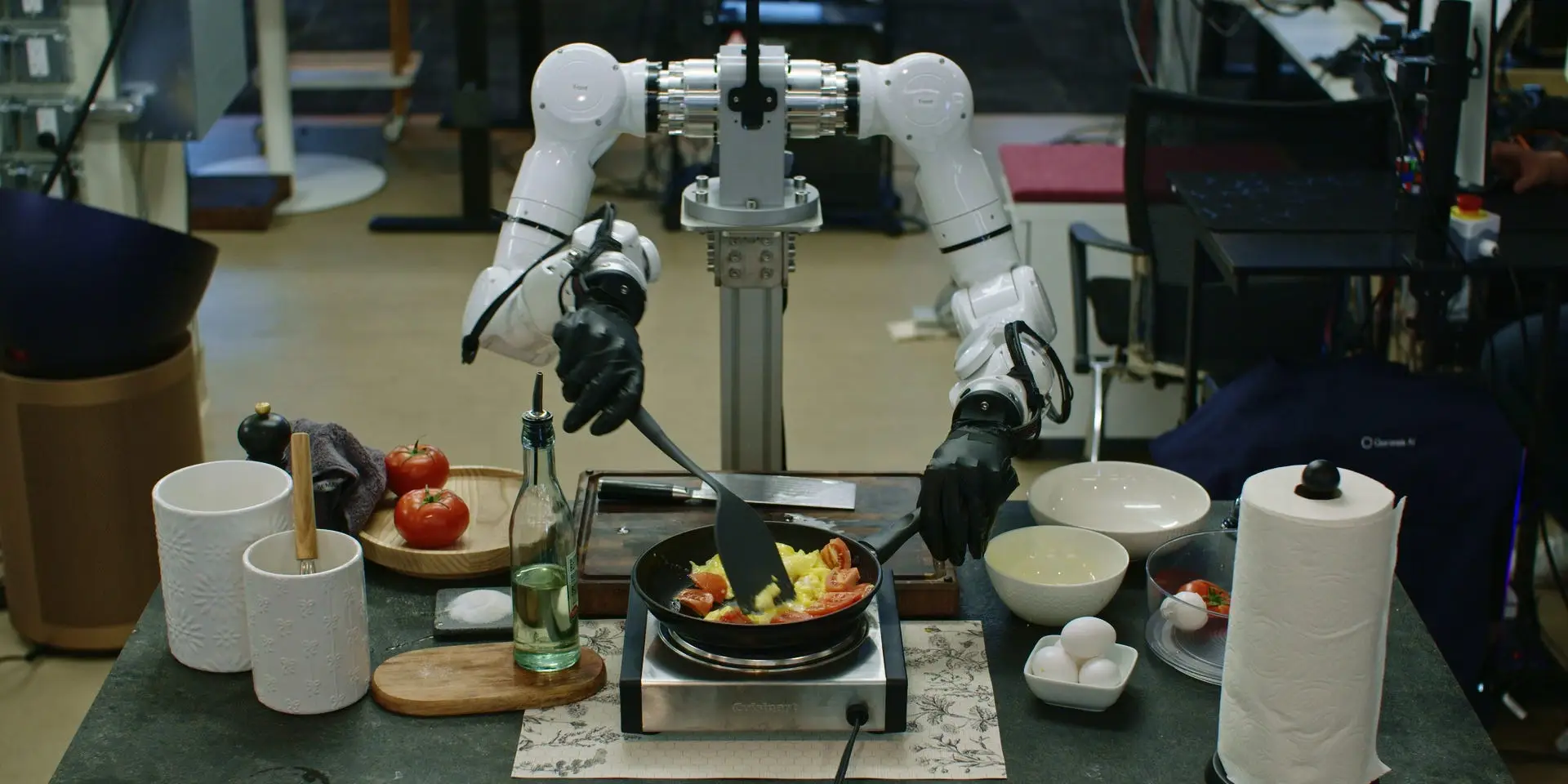 Robot arms cooking a tomato-and-egg dish