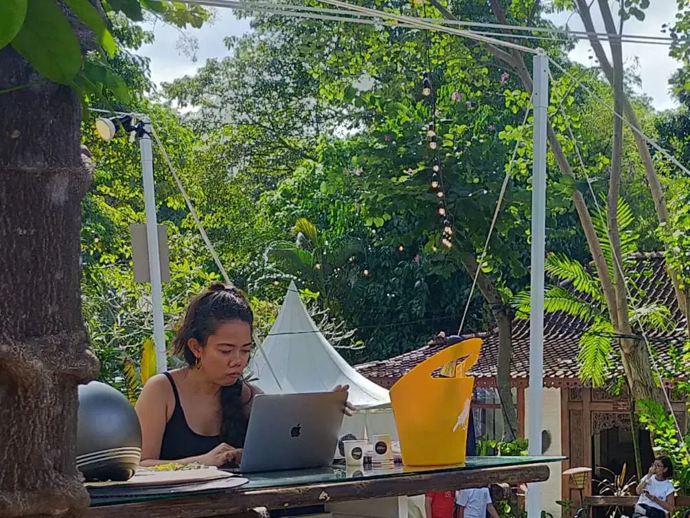 A woman working at a desk in Bali.