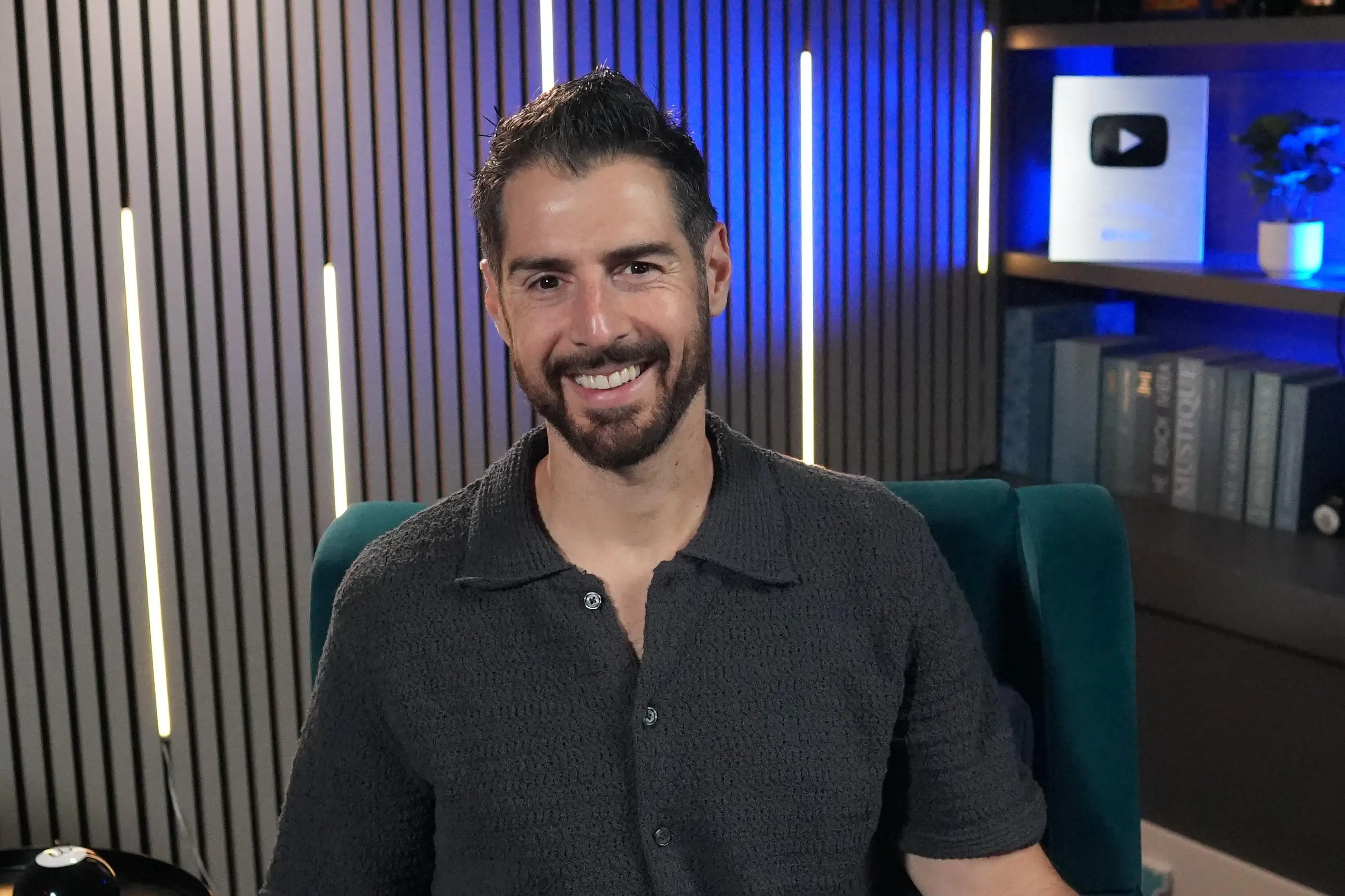 Reality star Rob Cesternino sits in a chair smiling at the camera.