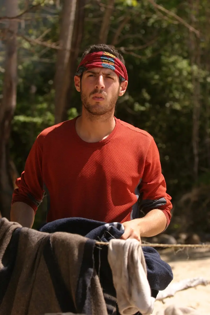 Rob Cesternino wearing a red buff standing in front of a clothesline on 