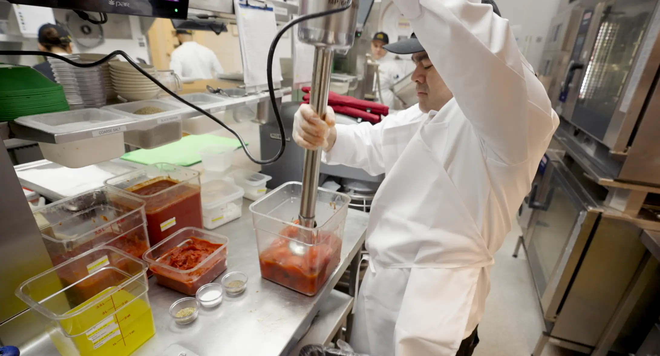 Cook with giant blender blend tomatoes for a sauce at The Cheesecake Factory.