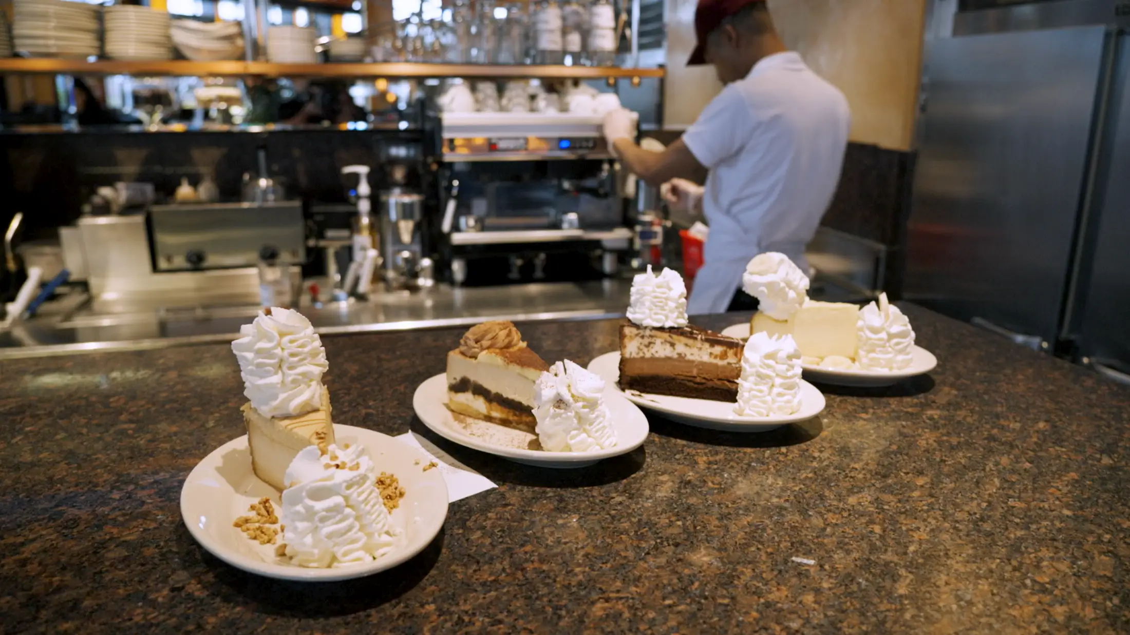 Four plates with four different cheesecakes from The Cheesecake Factory.