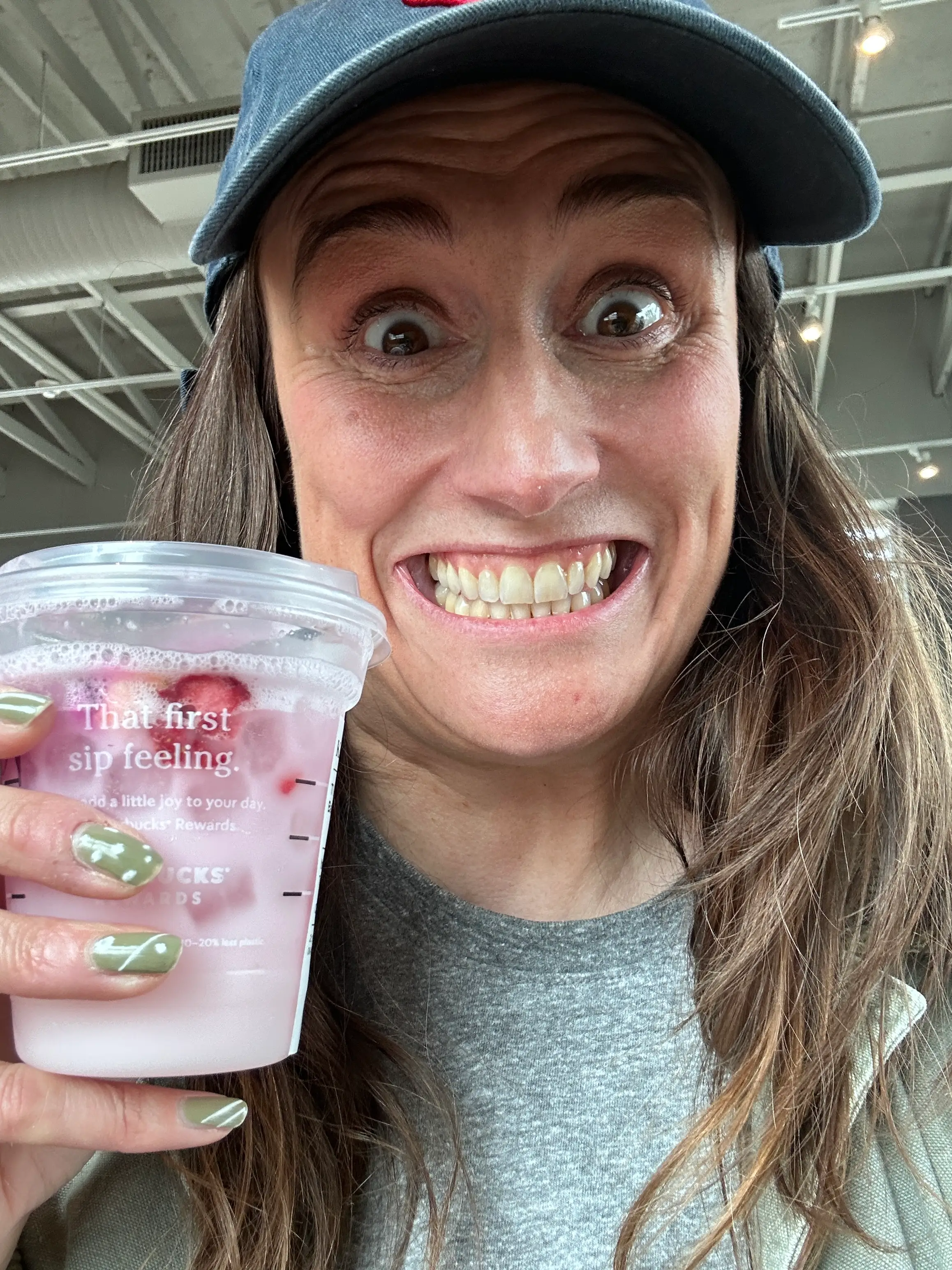 Woman smiling with a MrBeast-themed Starbucks drink.