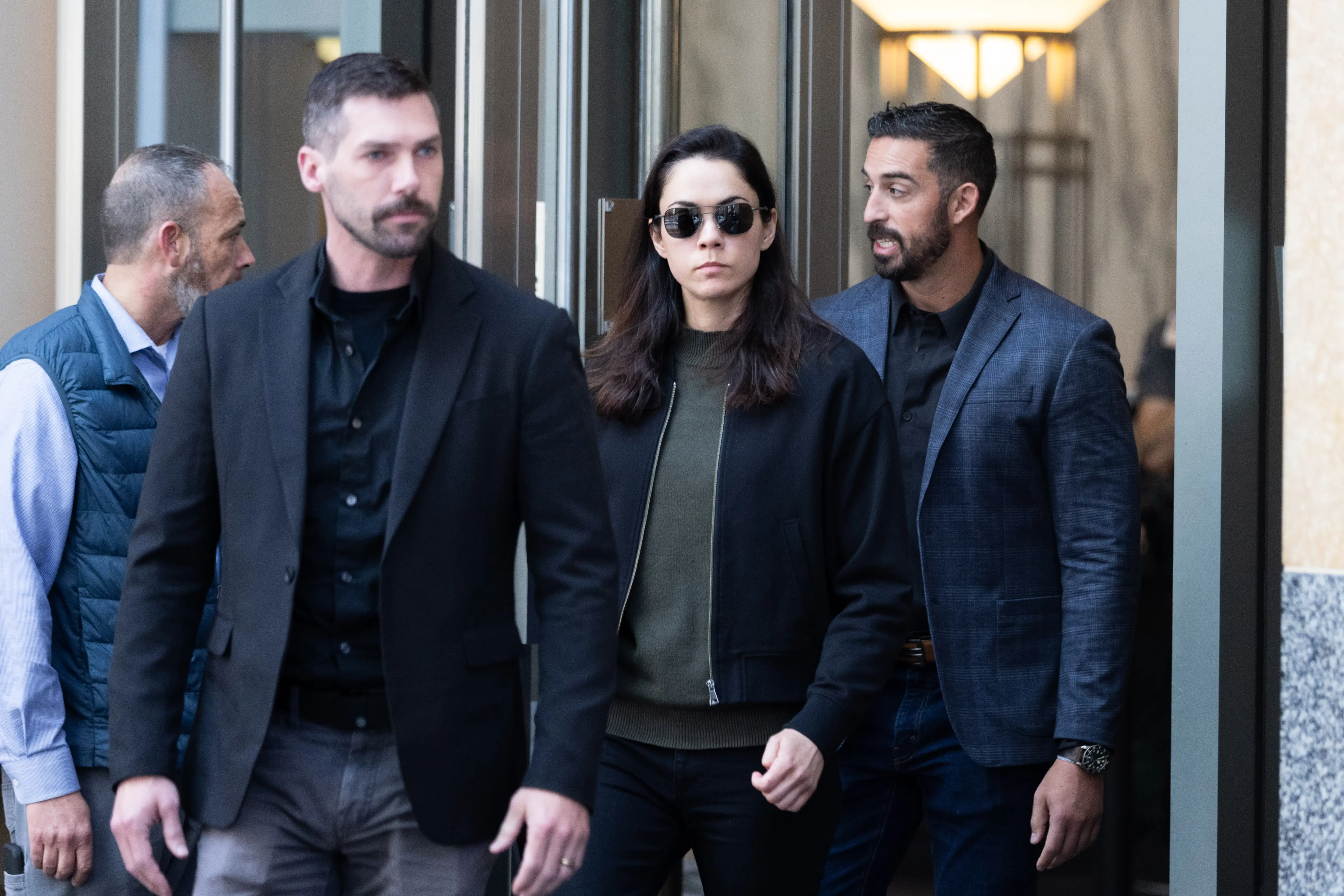 Shivon Zilis, flanked by several men, leaves court.