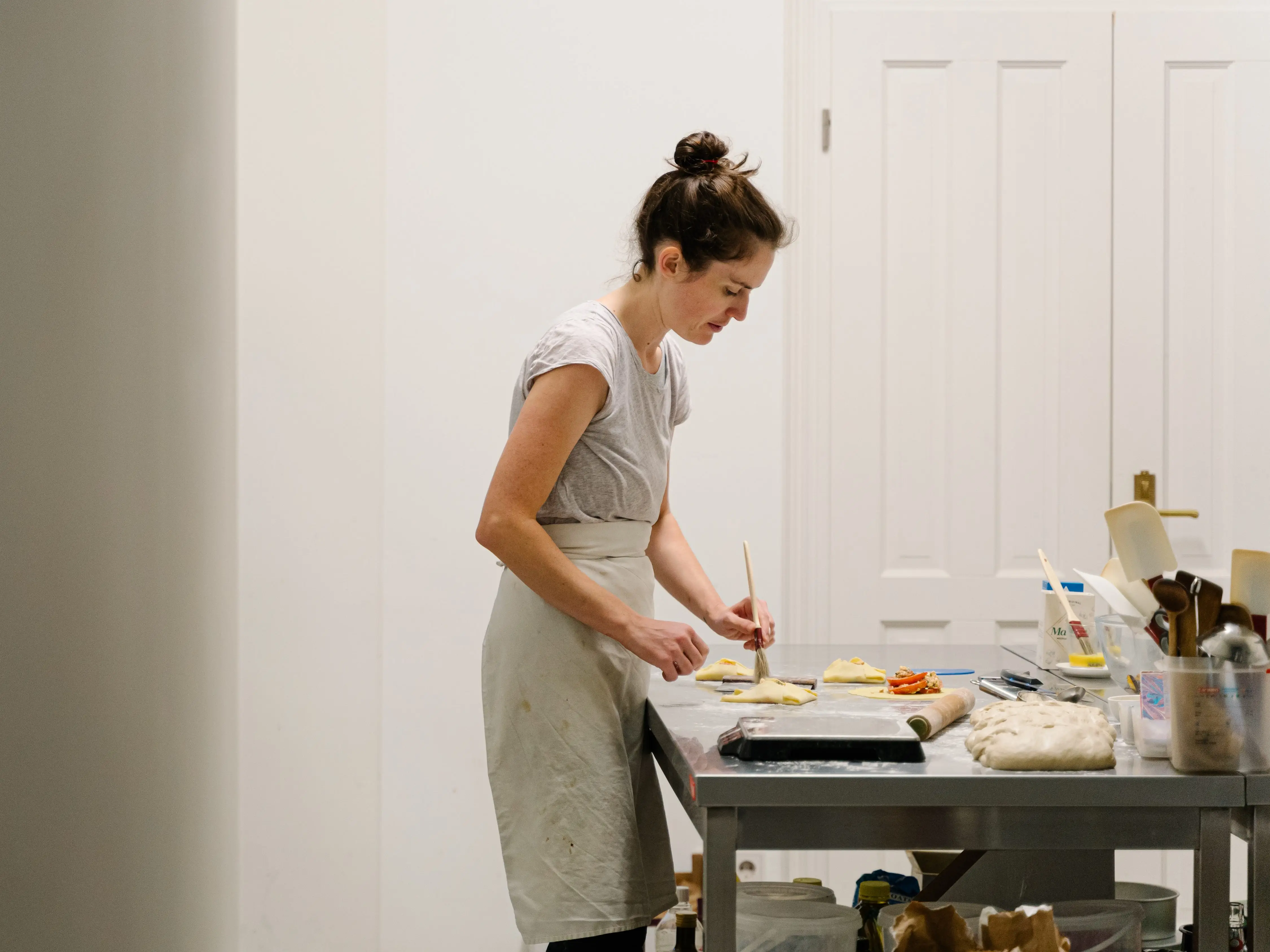 A woman baking in a room with white walls.