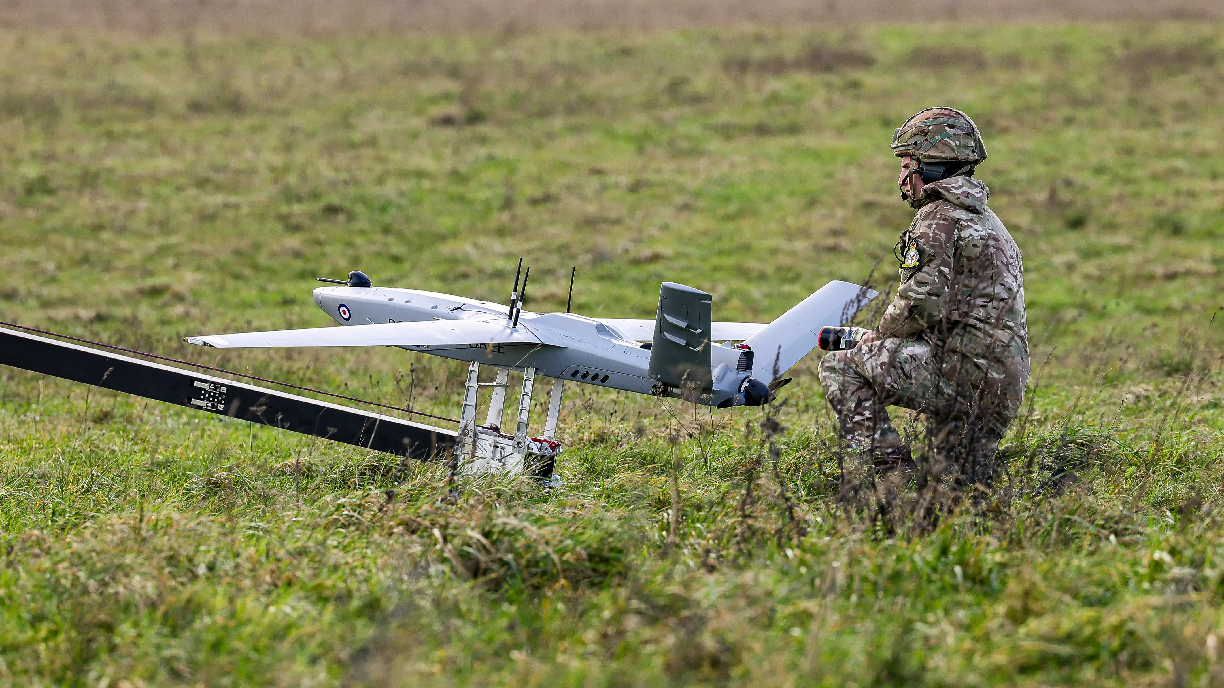 A soldier prepares a Stormshroud drone for launch.