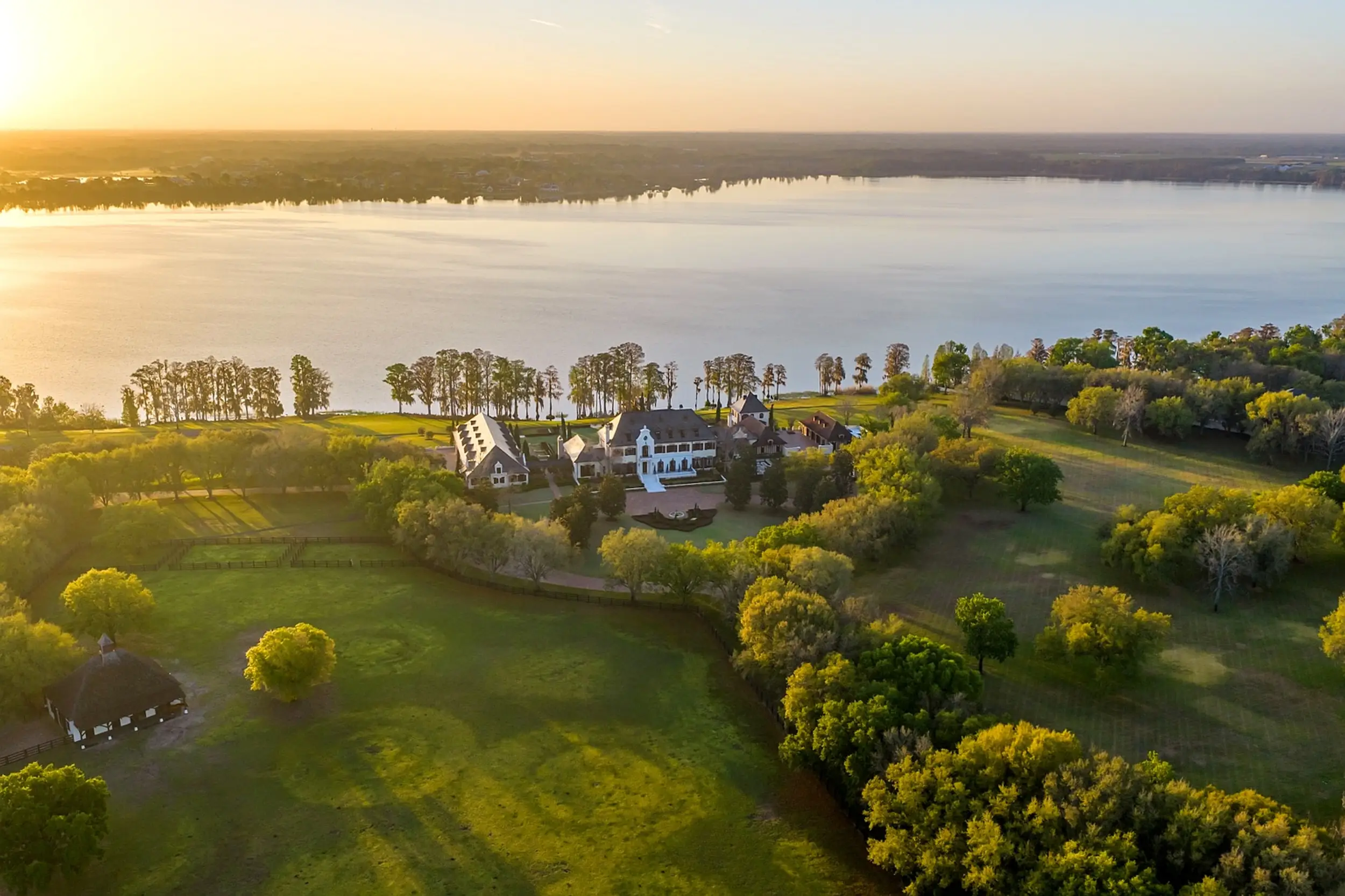 An aerial view of a large residential compound on a lake.
