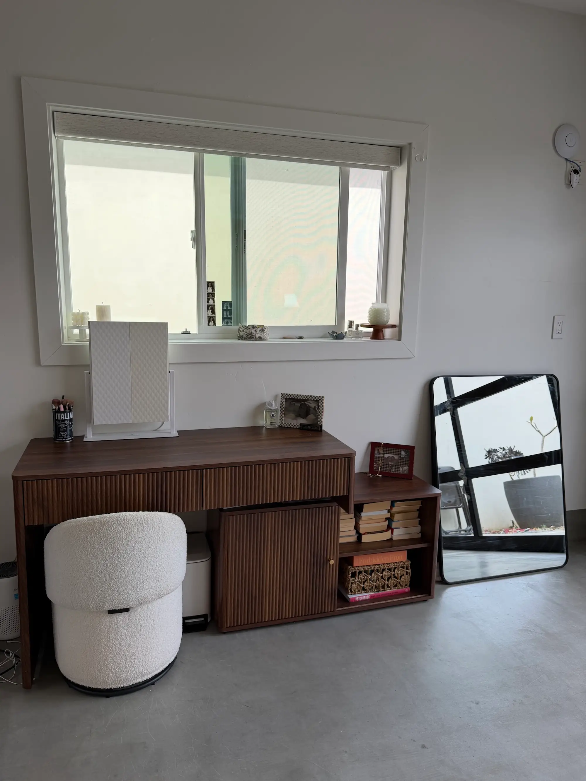 A vanity and mirror in front of a window inside a garage.