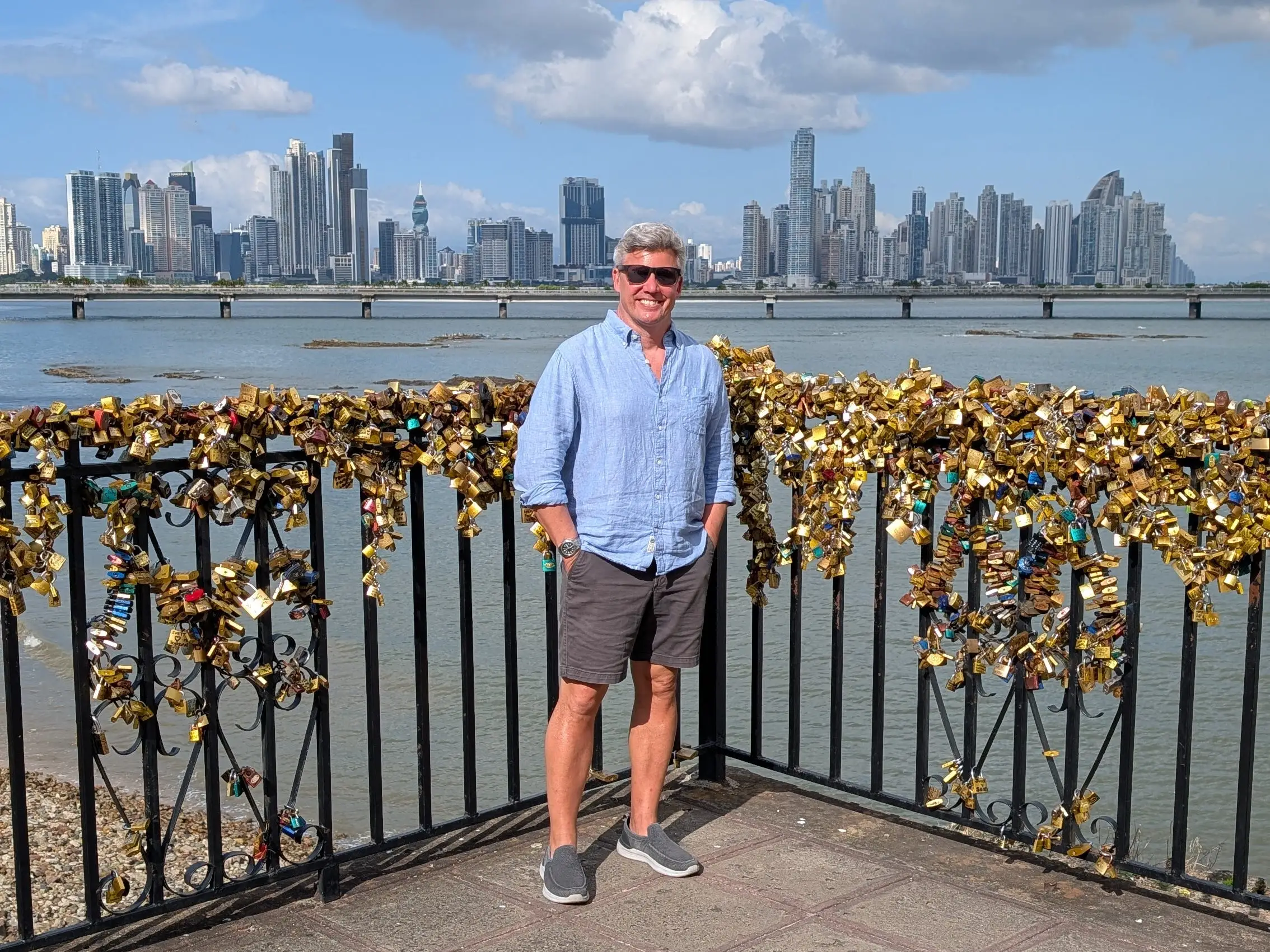 Matt Lowrie is standing in front of a body of water with a skyline view