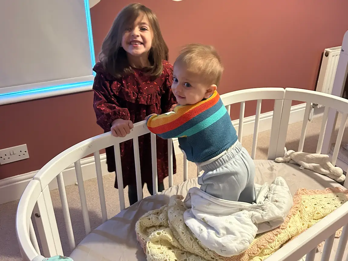 Baby in crib with sibling