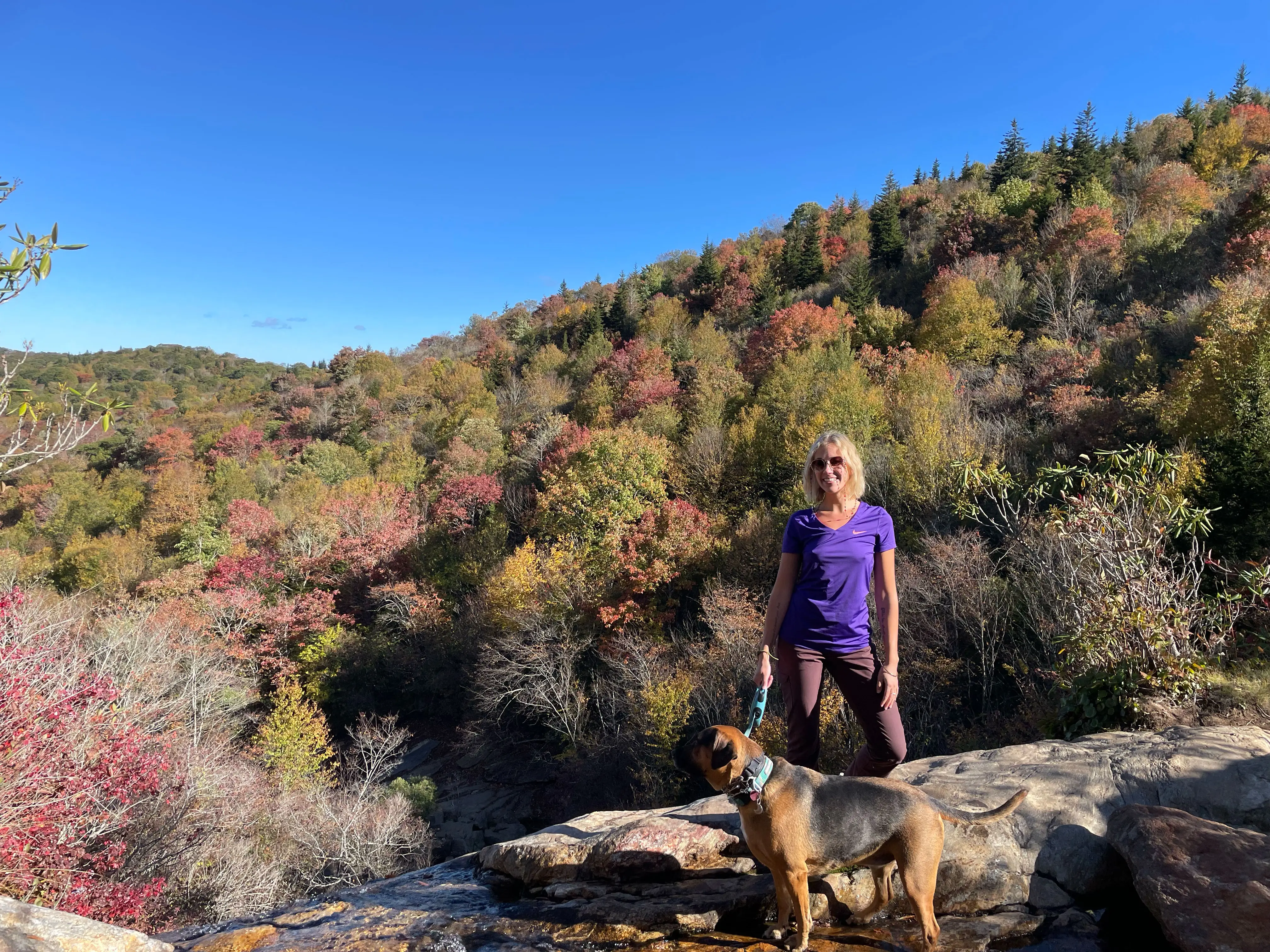 Mikala hikes with her dog in the mountains on a fall day.
