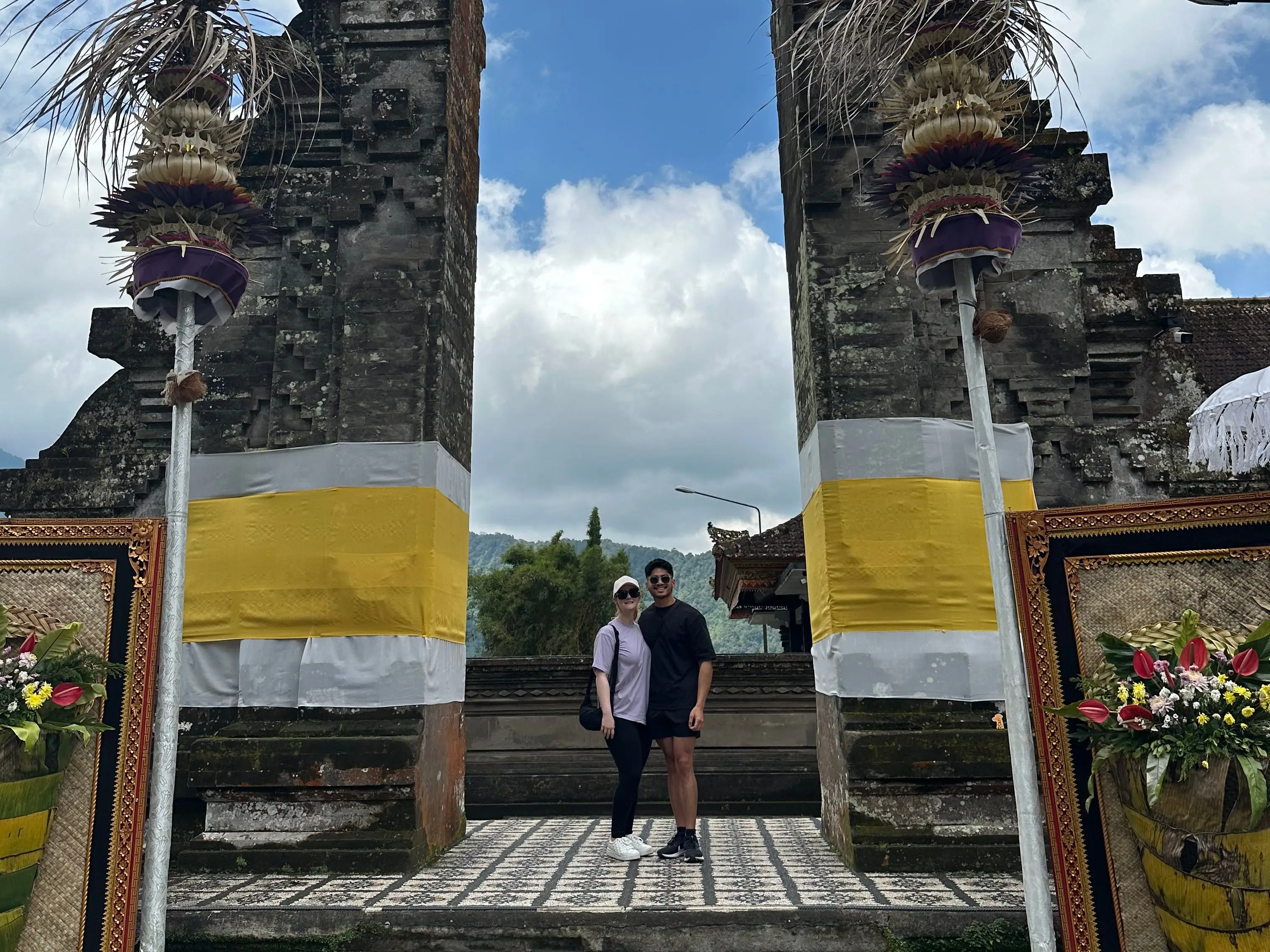 Man and woman posing together between two large stone structures