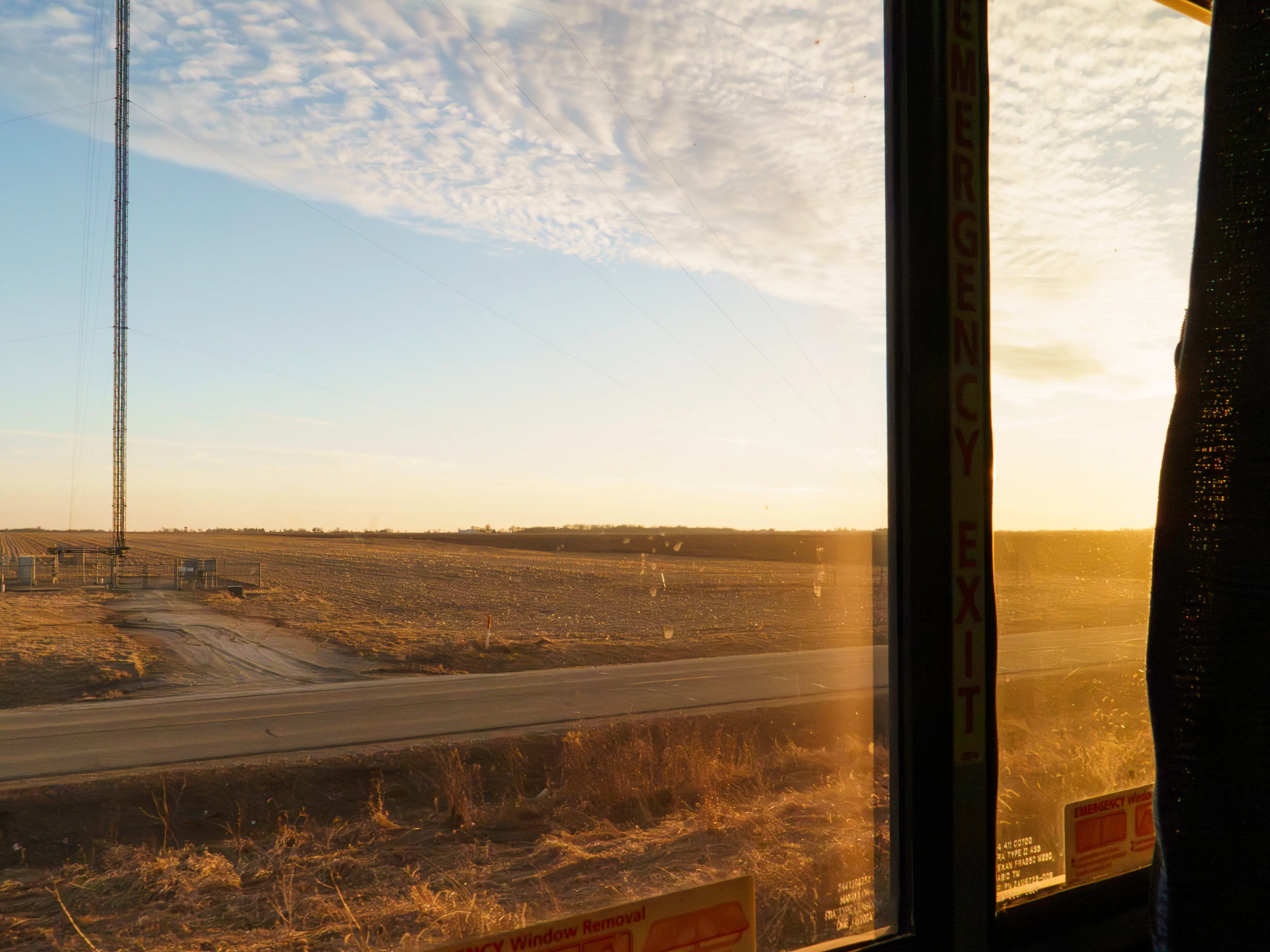 A view of plains as the sun sets out the window of a train