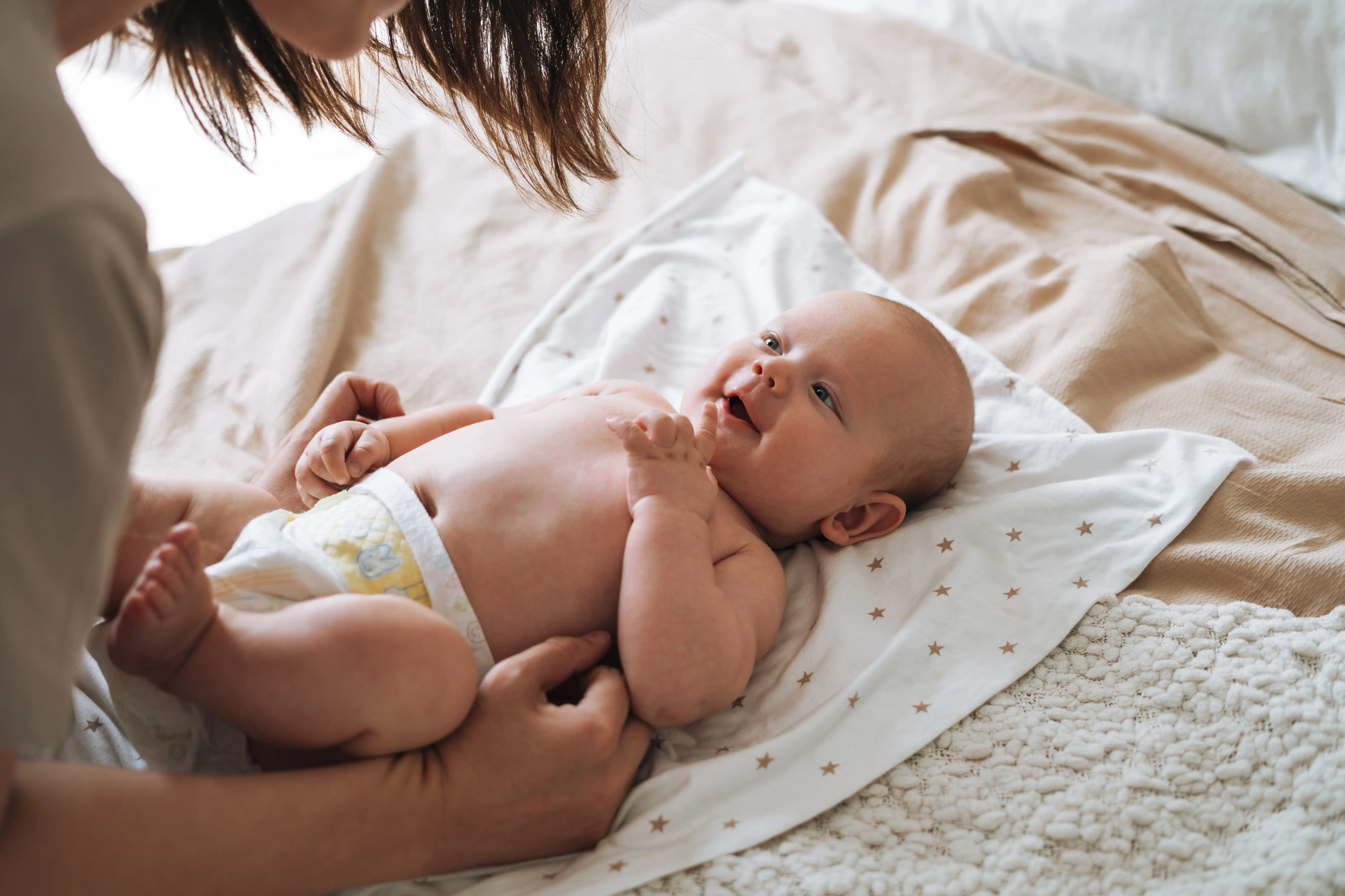 A woman changes a baby's diaper.