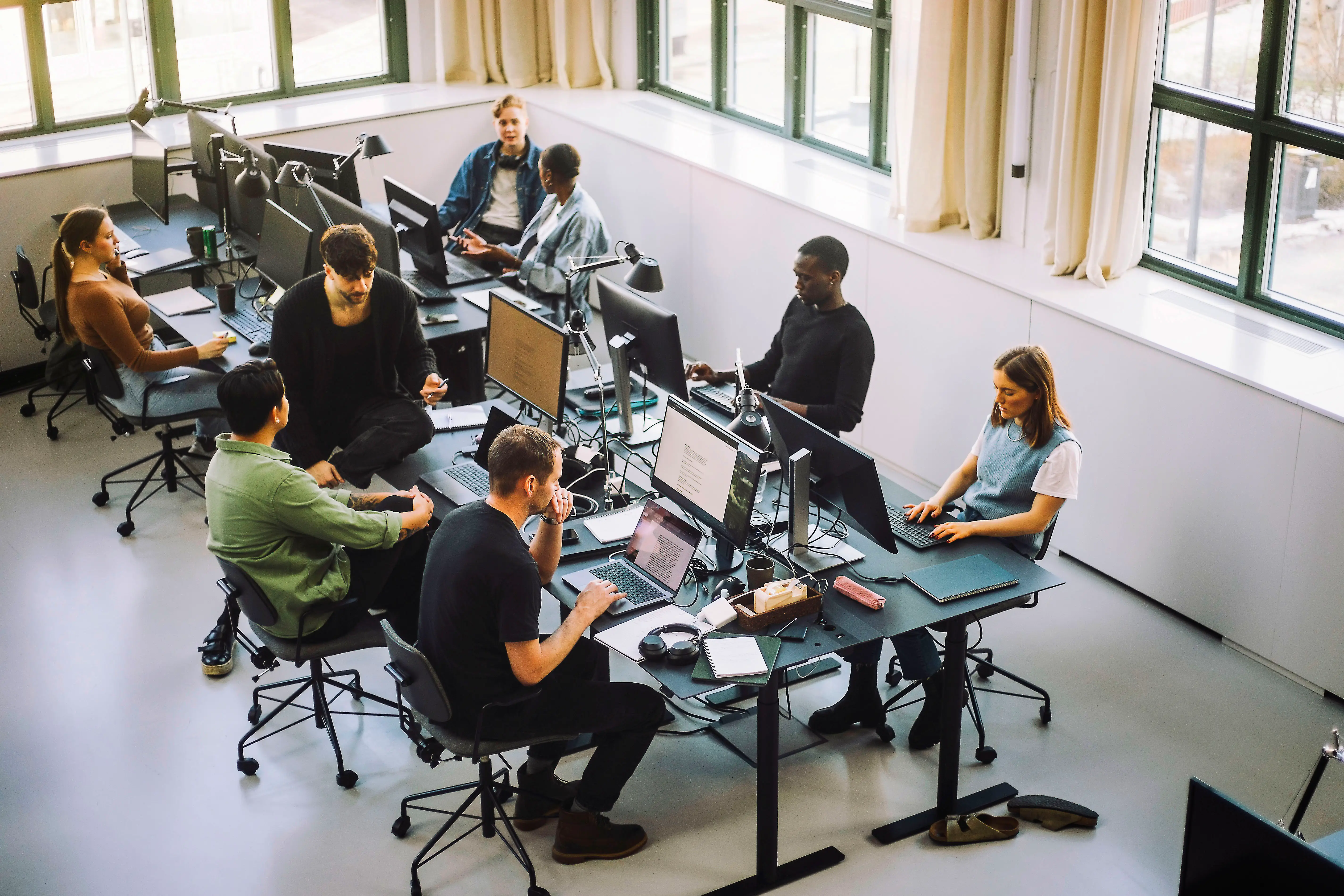 High angle view of male and female programmers working on computers at desk in office
