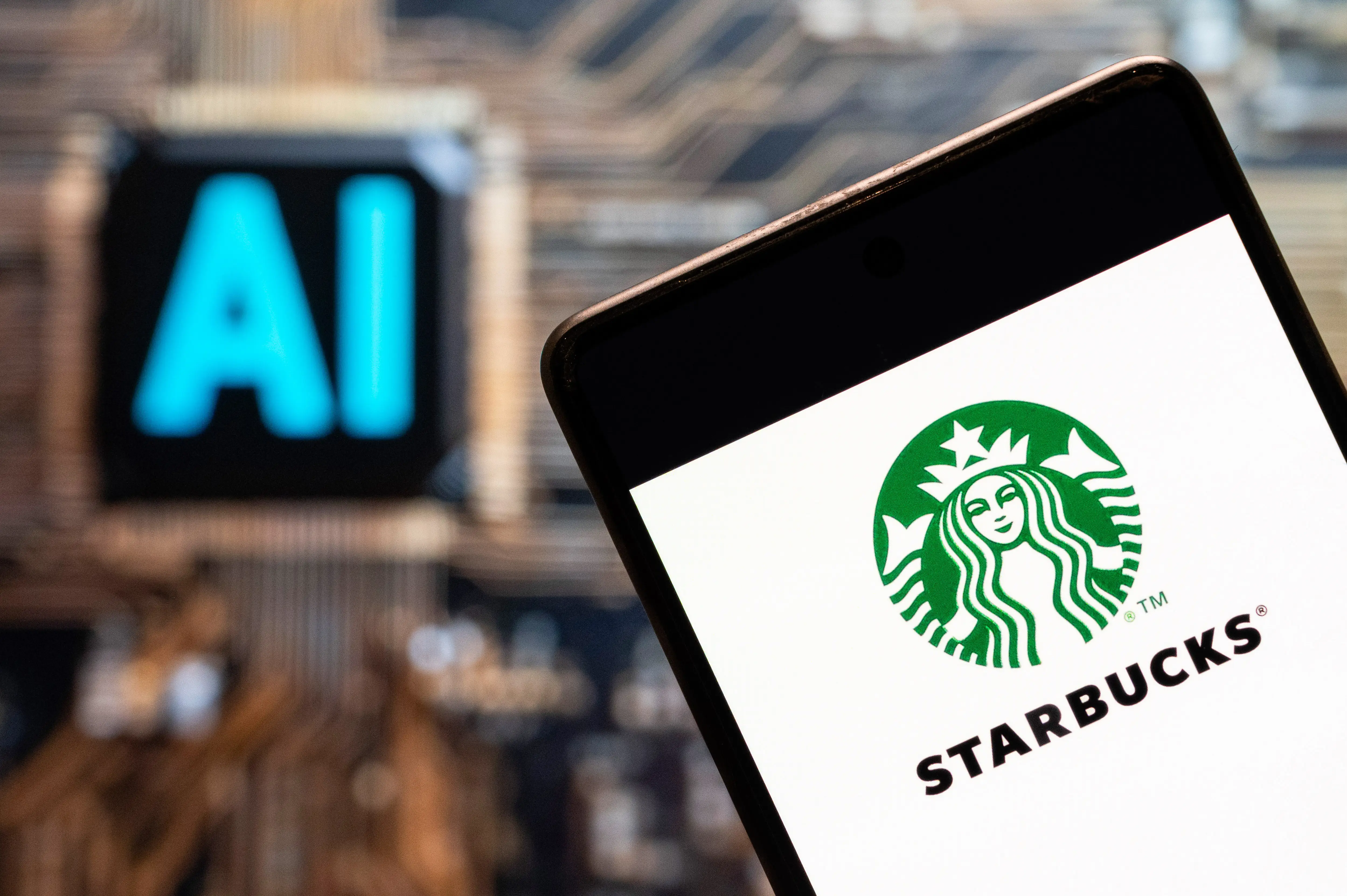 A Starbucks logo appears on a phone in front of an illuminated illustration of AI.