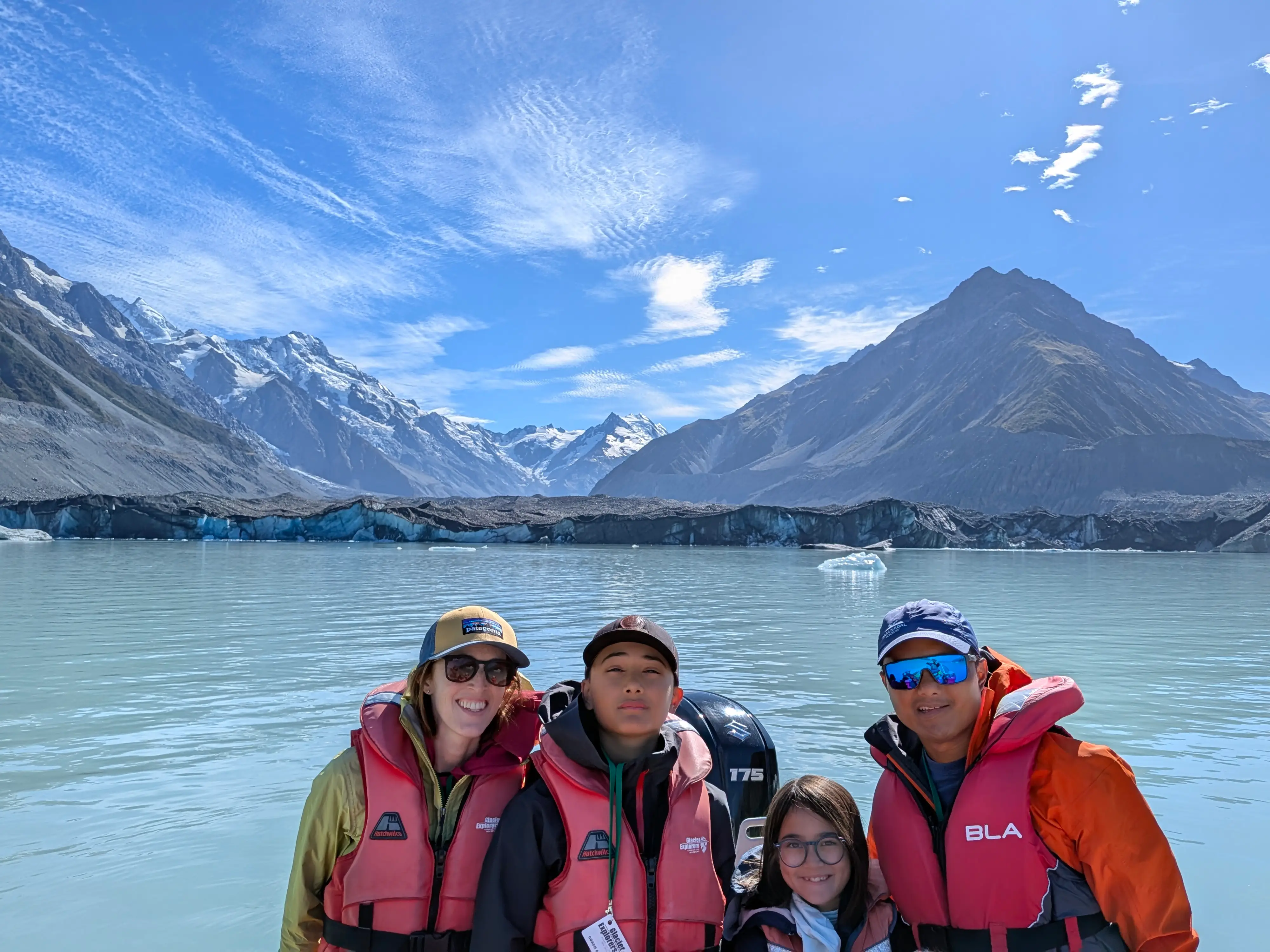 Family in life jackets with New Zealand's Mount Cook National Park in the background.