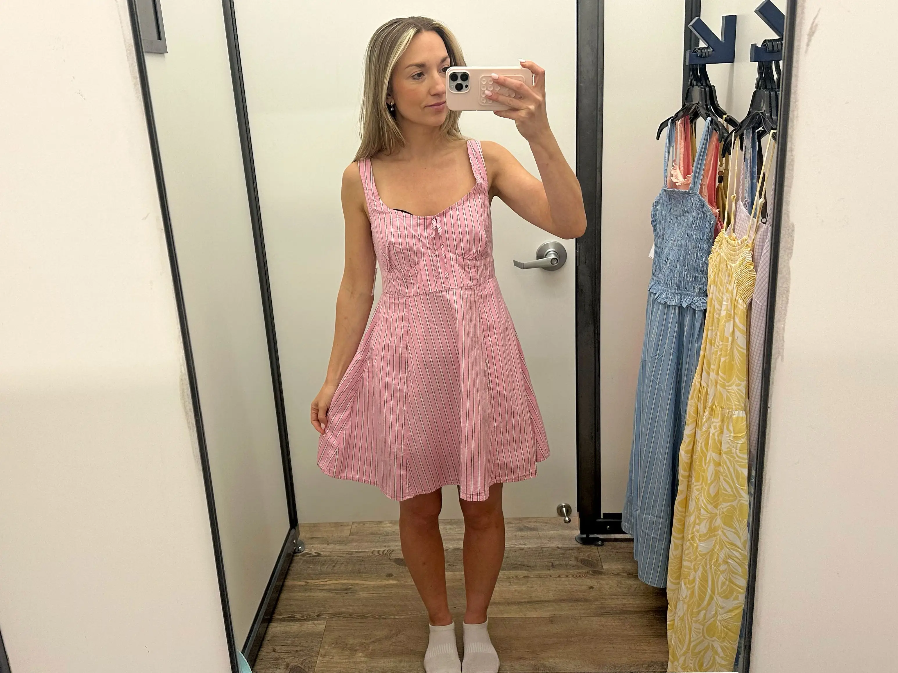Chloe wearing a pink and white striped mini dress.