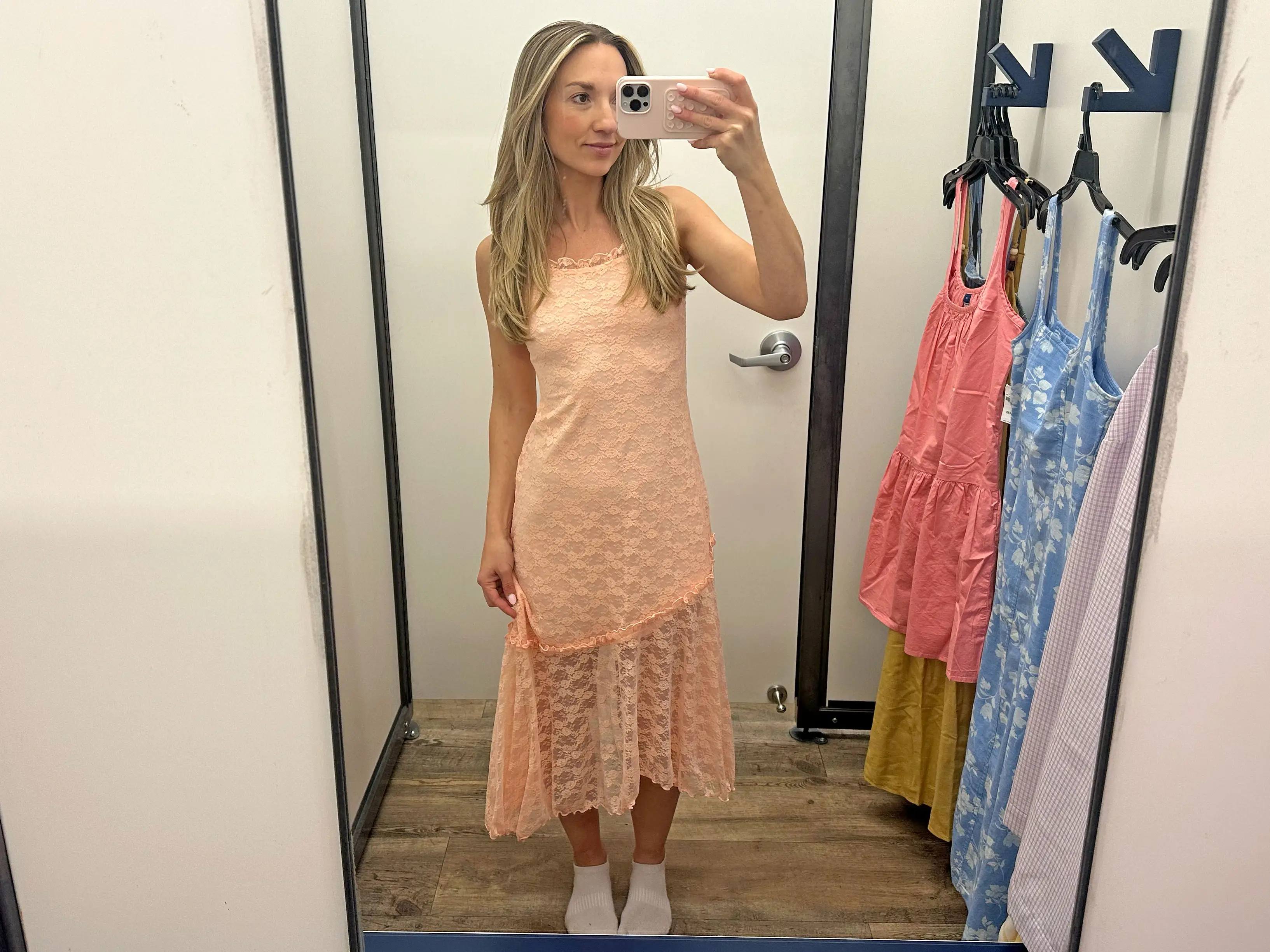 Chloe wears a peach lace midi dress.