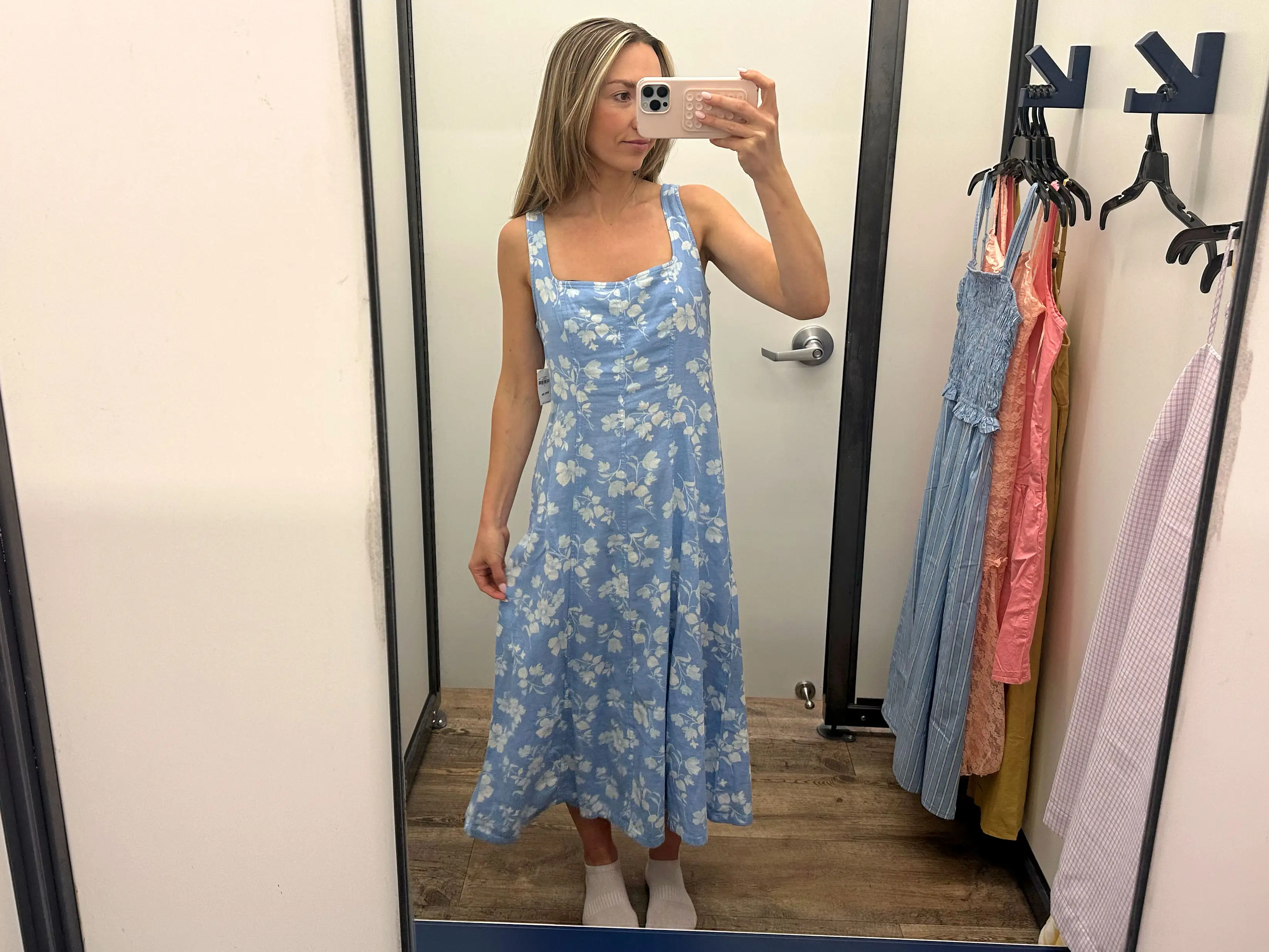 Chloe wears a blue midi dress with white flowers.