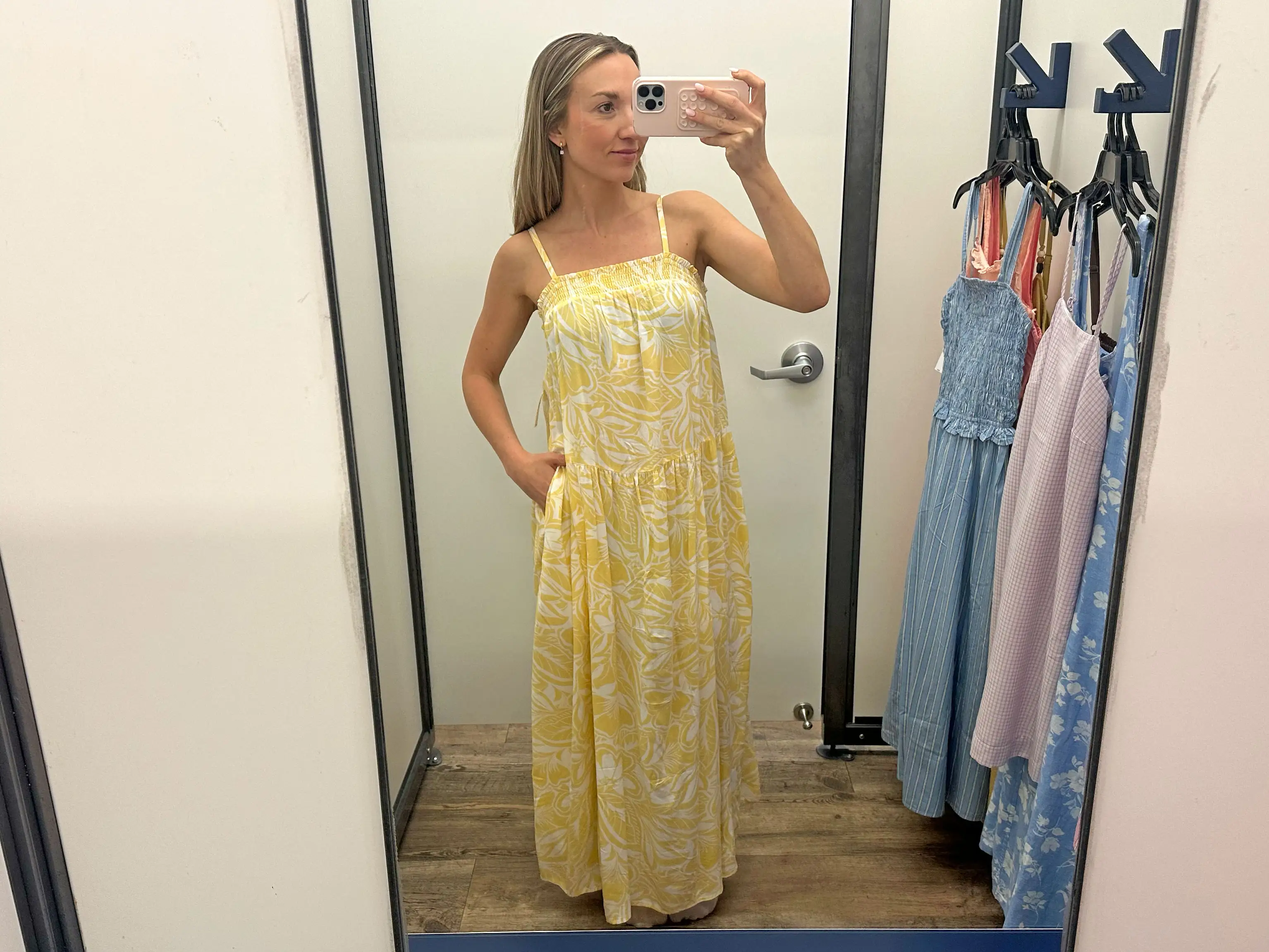 Chloe wears a yellow-and-white patterned maxi dress with pockets.
