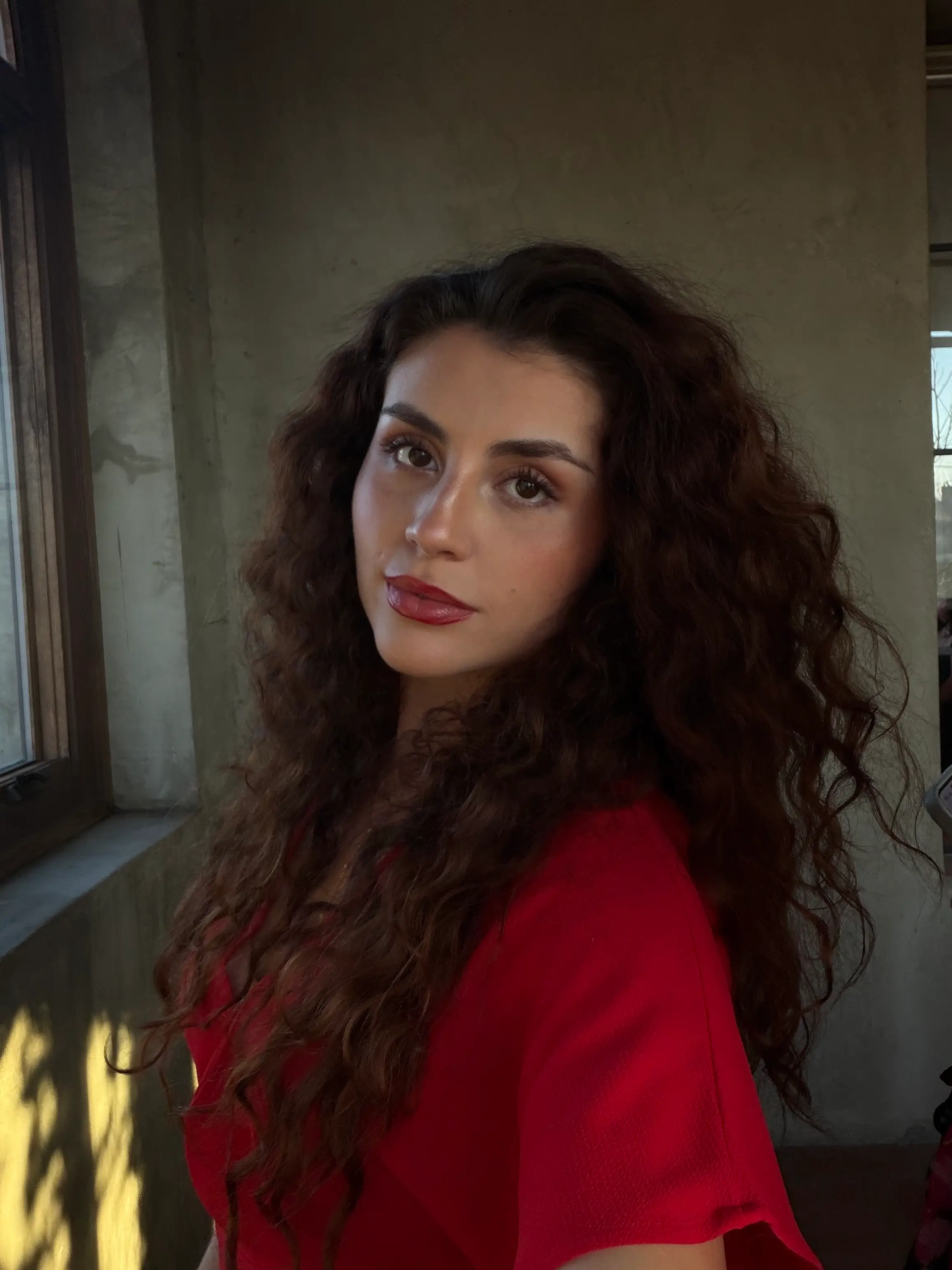 A selfie of a woman wearing a red shirt.