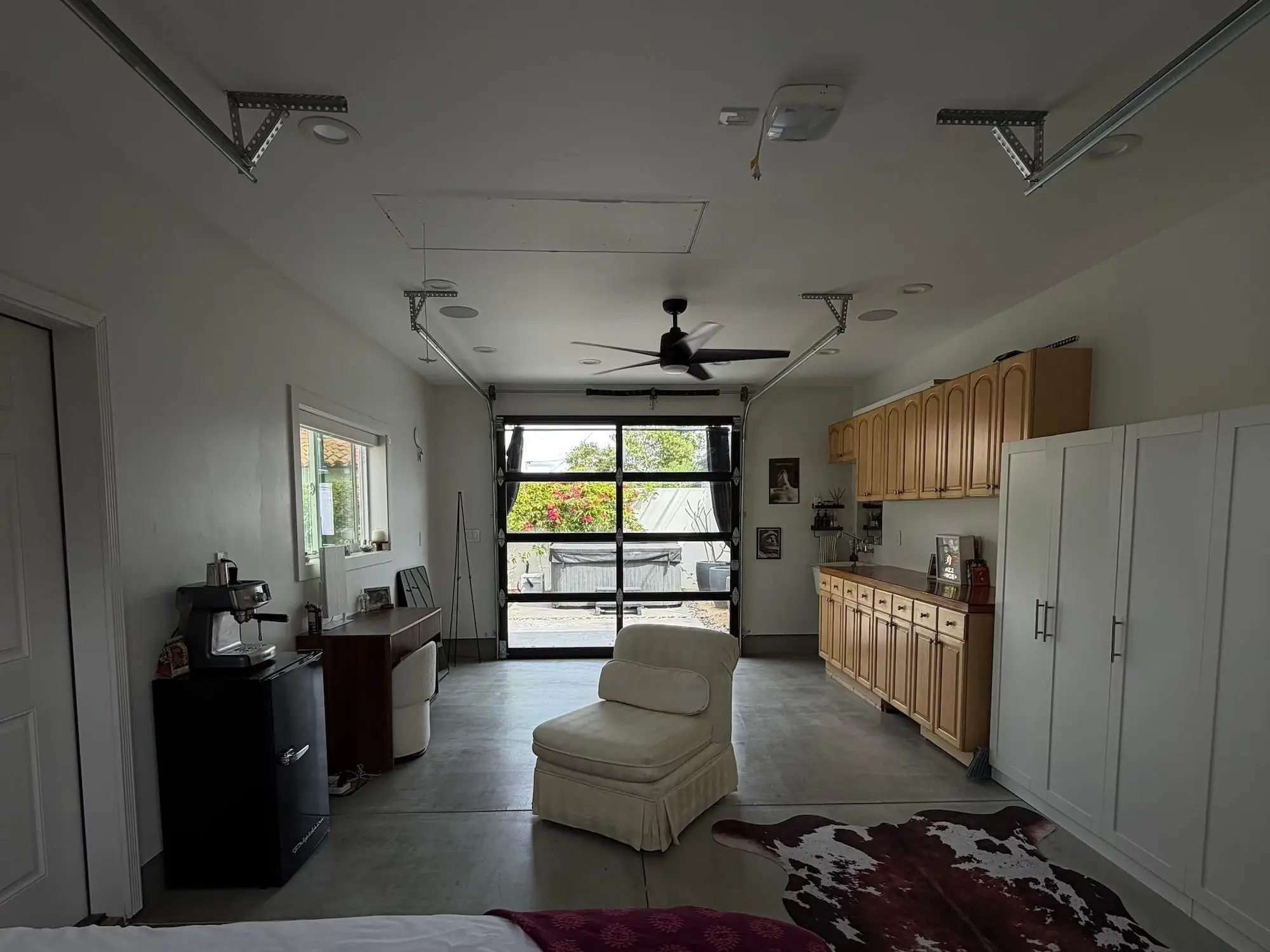 A garage set up as an apartment with cabinetry and furniture.
