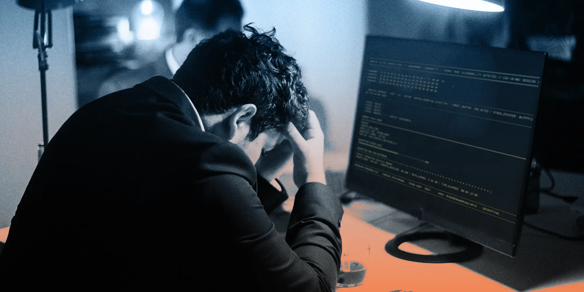 A tech employee visibly looking stressed at a desktop computer