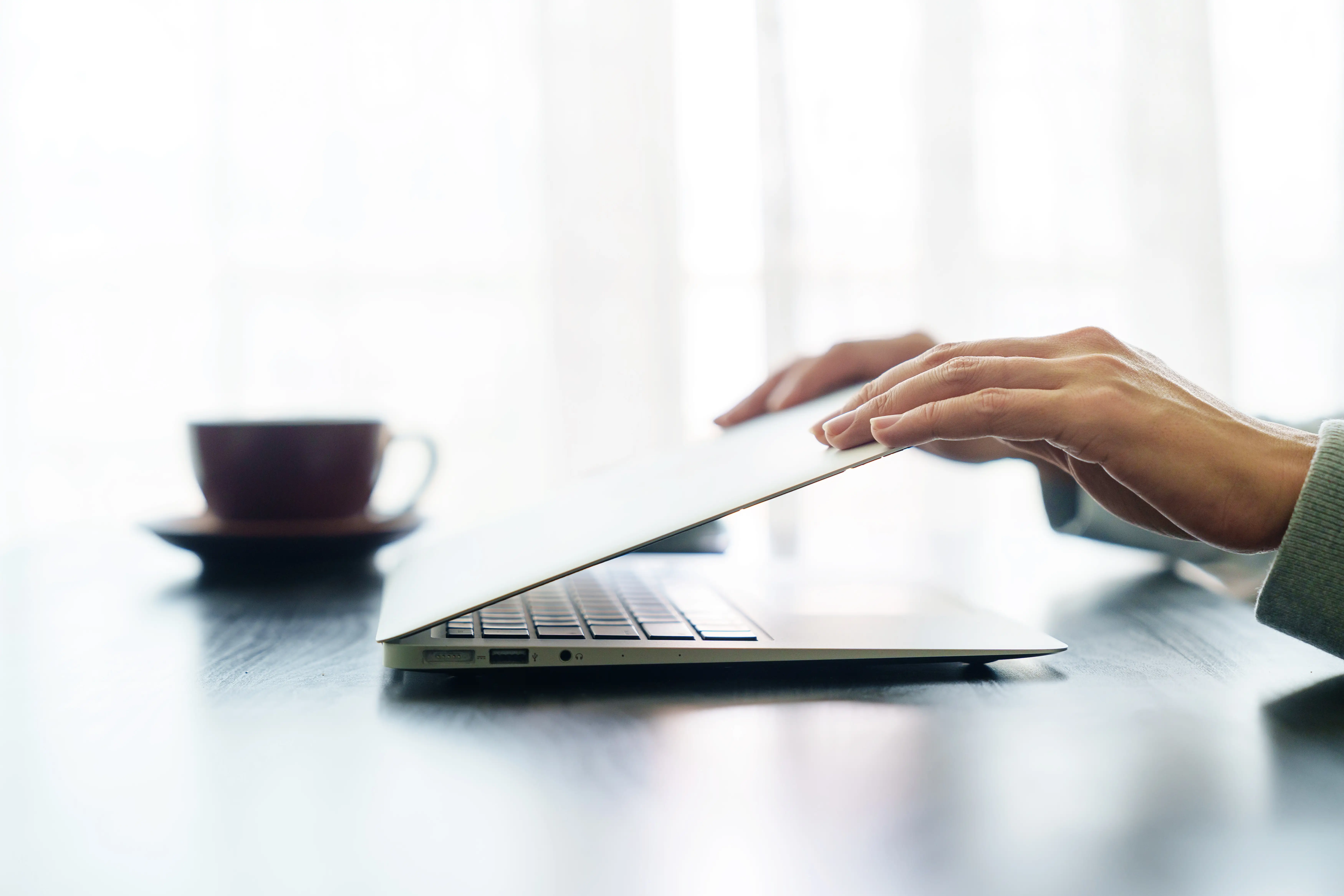 A person is pictured shutting a laptop.