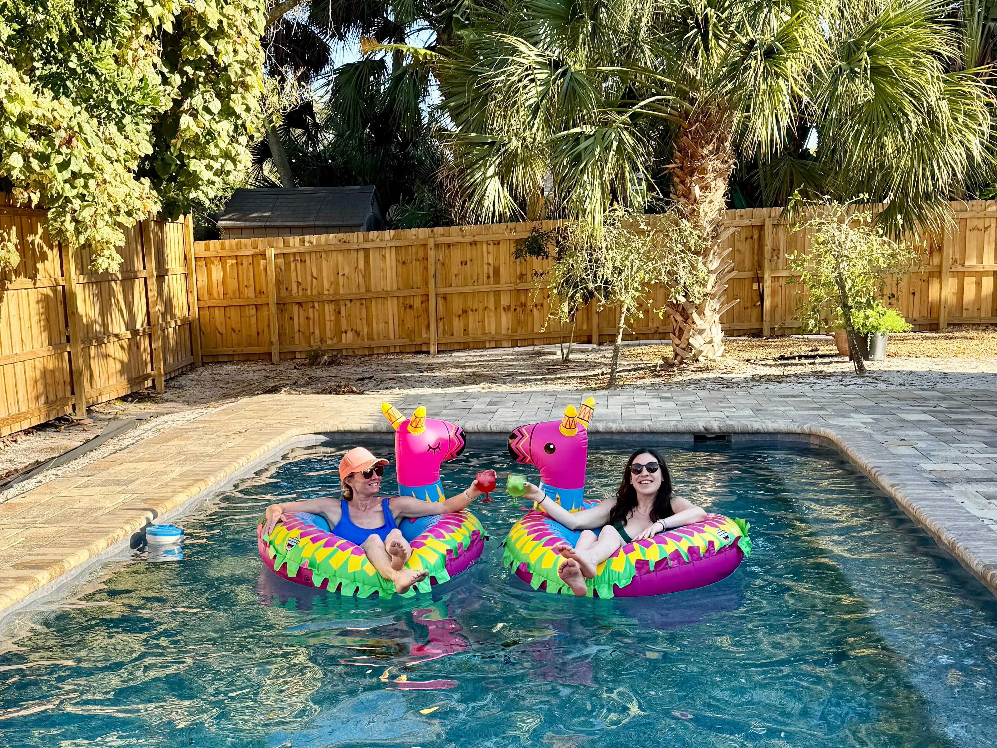 Two women in pool on floats in yard