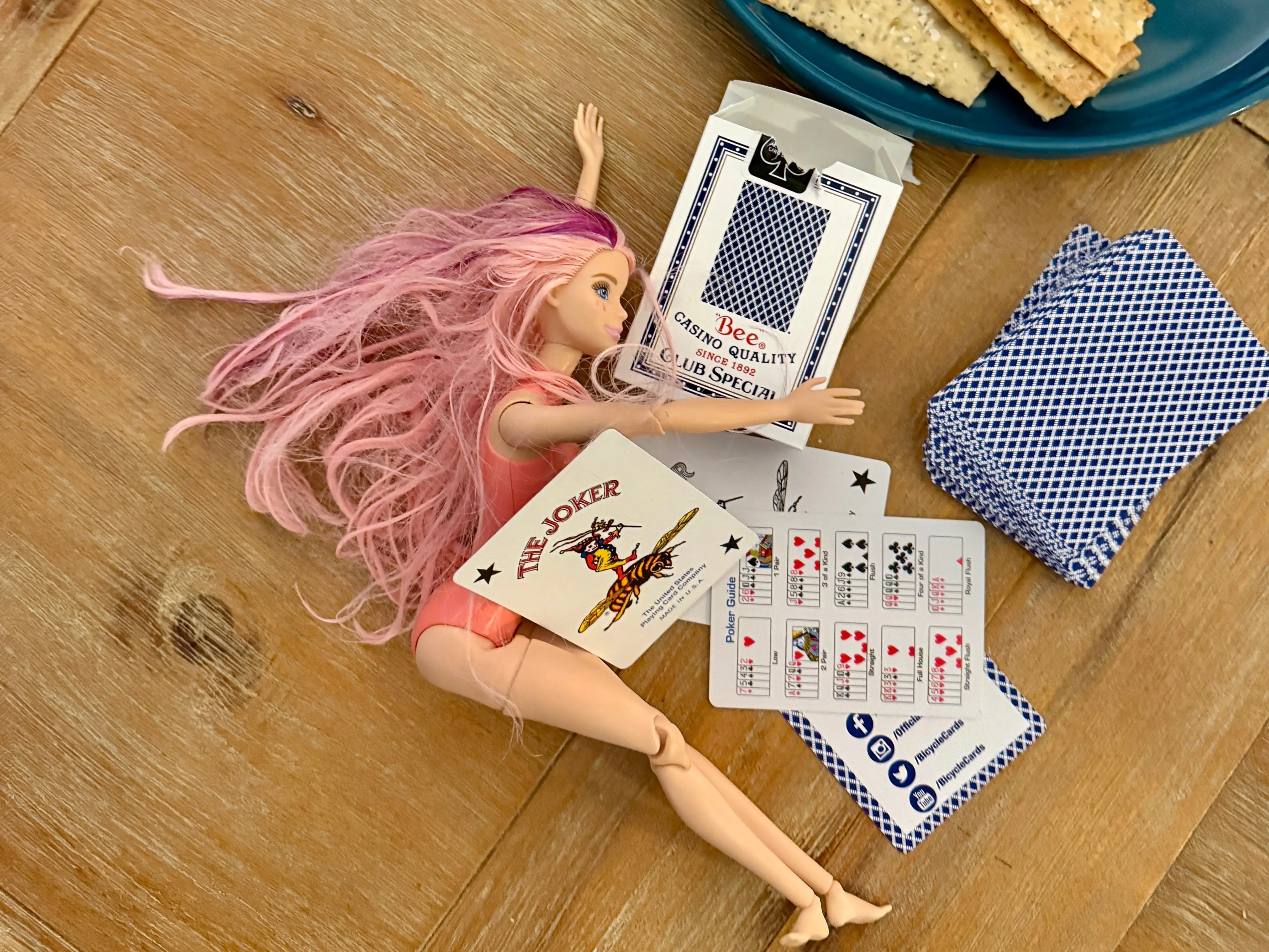 Barbie doll with deck of cards on table
