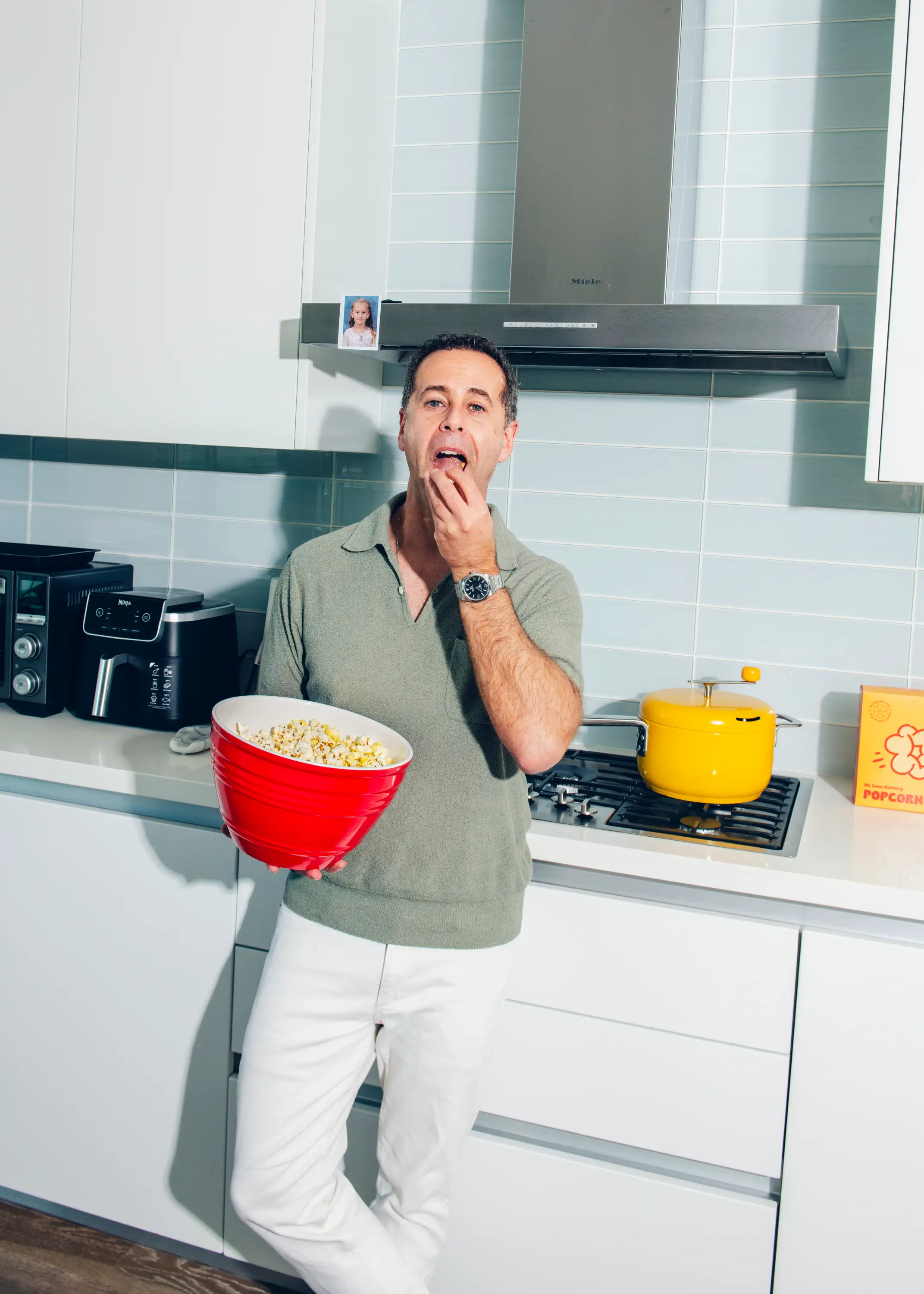 Tal Moore, Founder of Popsmith, eating popcorn in his kitchen.