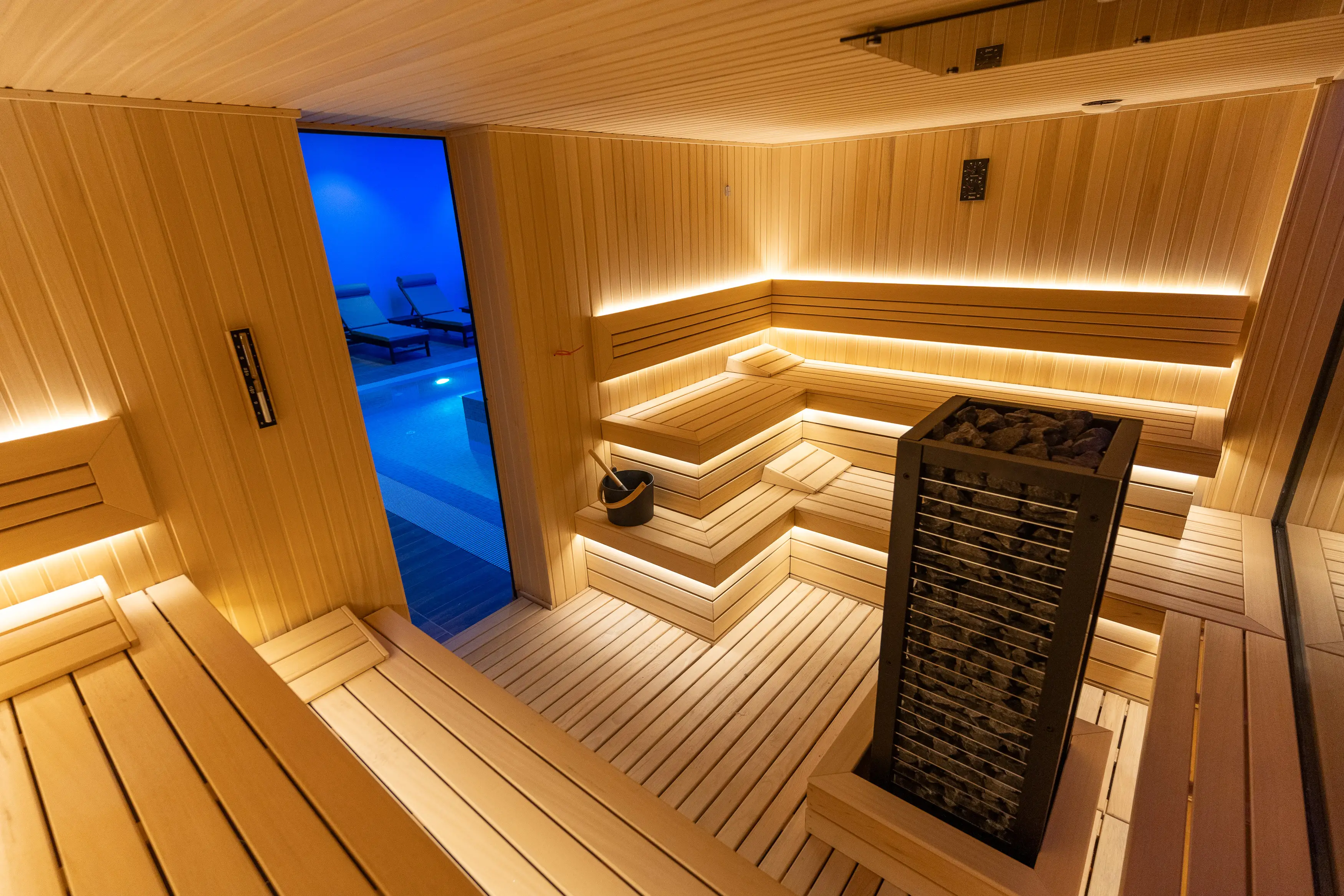 A sauna interior crafted with a view of a serene indoor pool.