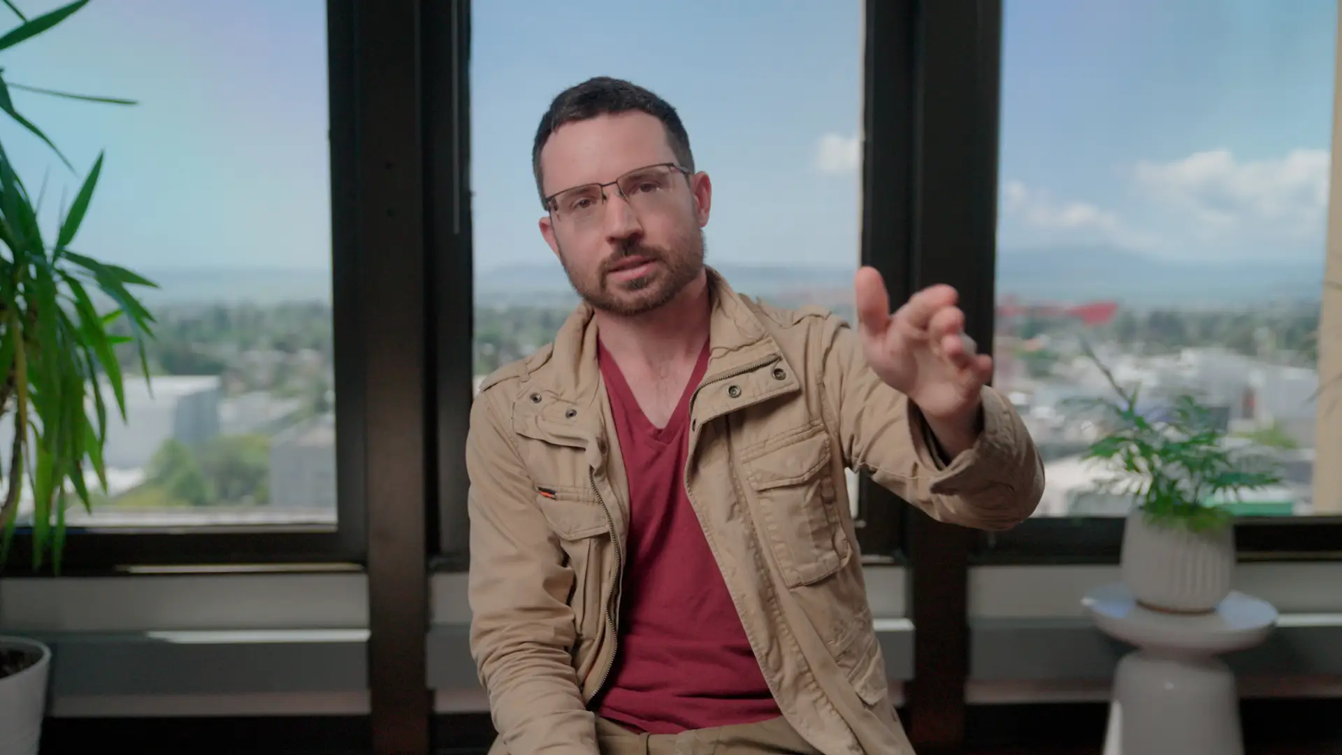 Daniel Kokotajlo in a red shirt and light brown jacket.