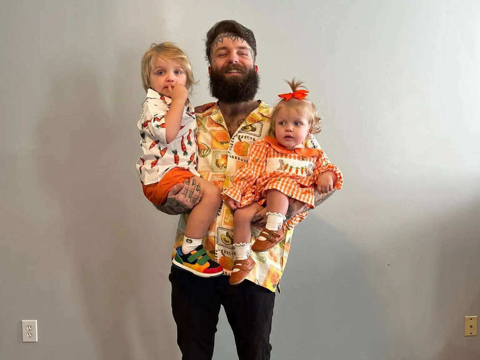 A man holding two young children